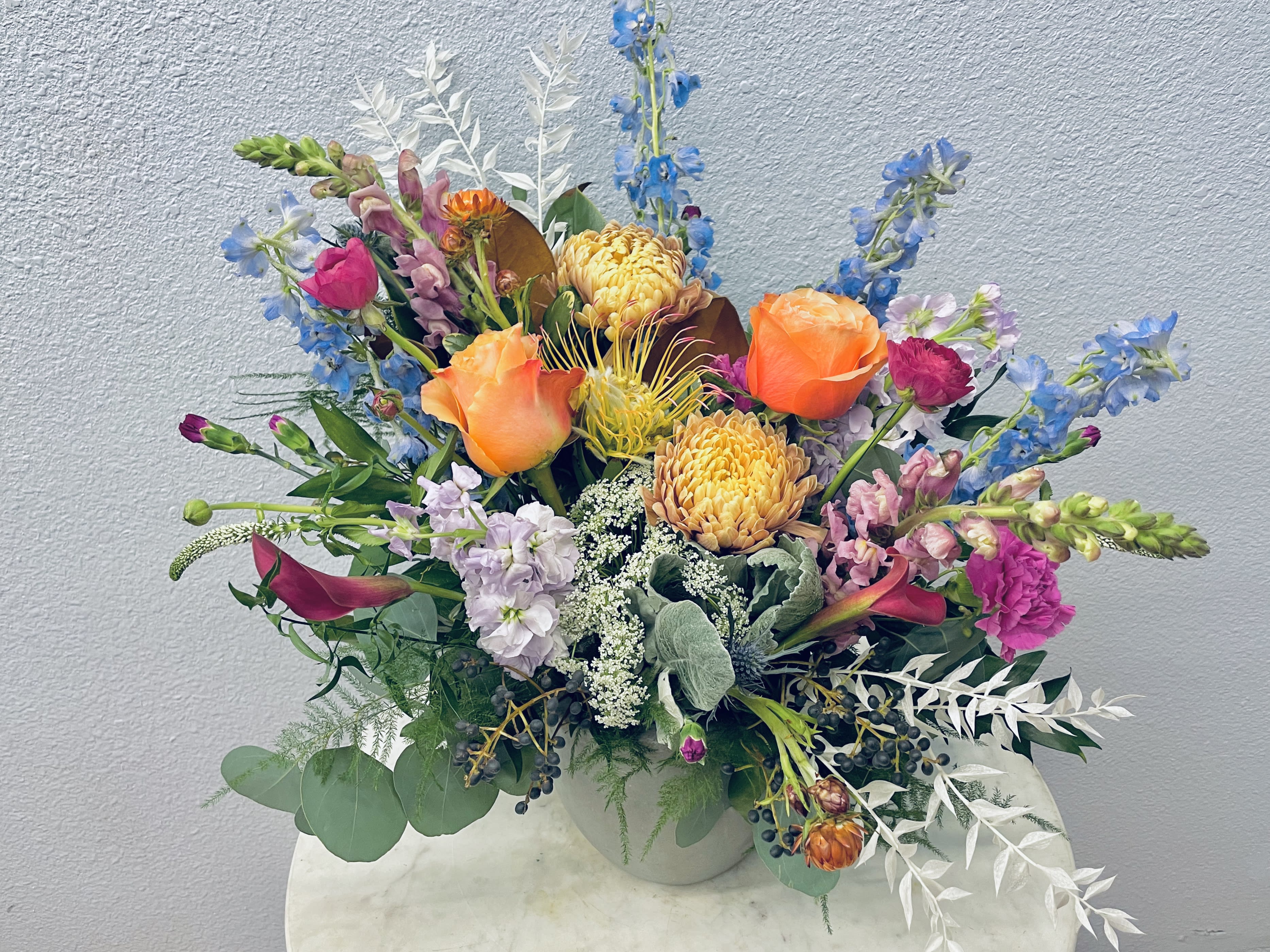 Colorful mixed flower arrangement in a white vase