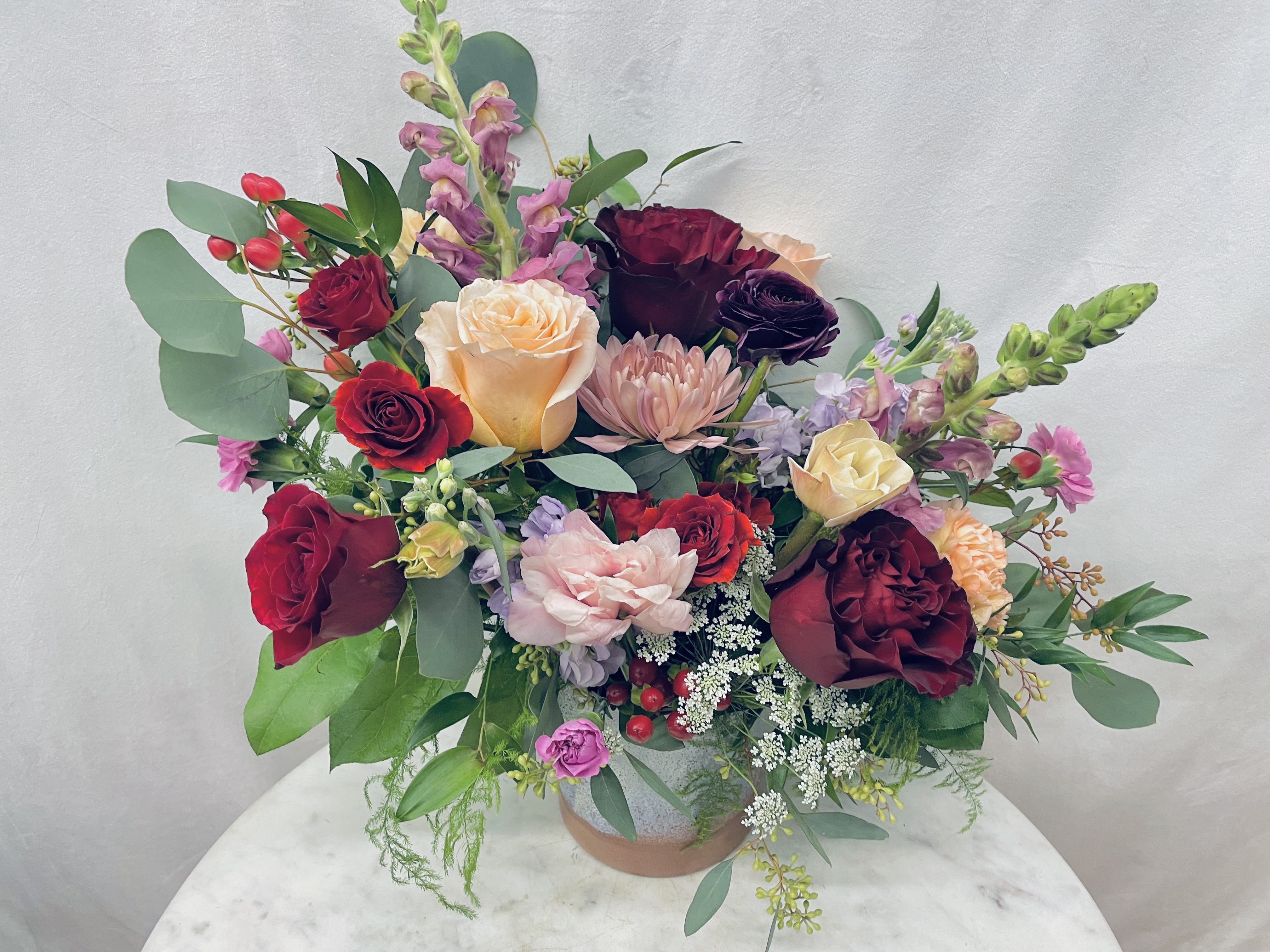 Mixed bouquet of roses and pink blooms in a vase