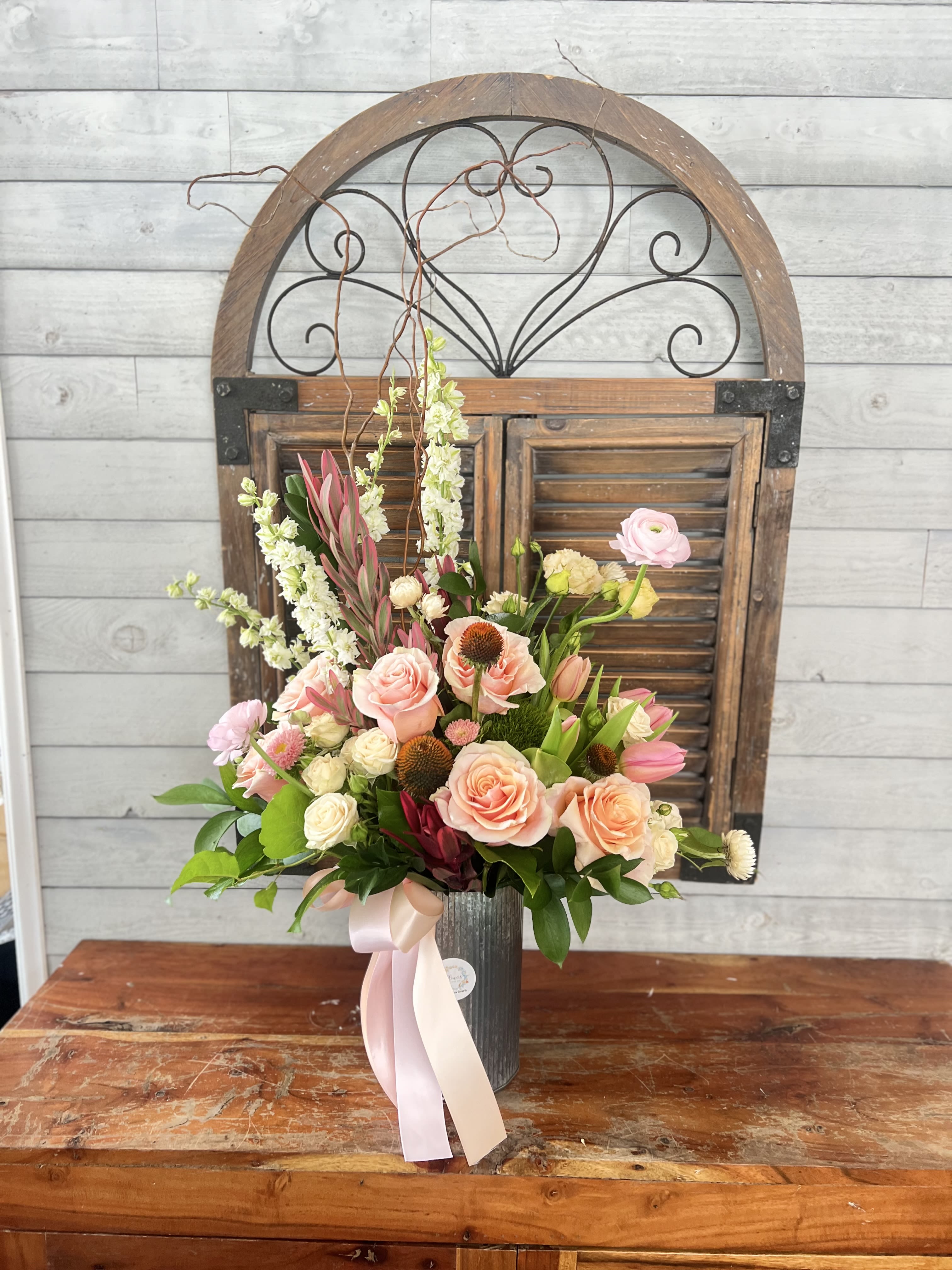 Sweet Touch  - Peach flowers and brown accents in metallic rustic container.