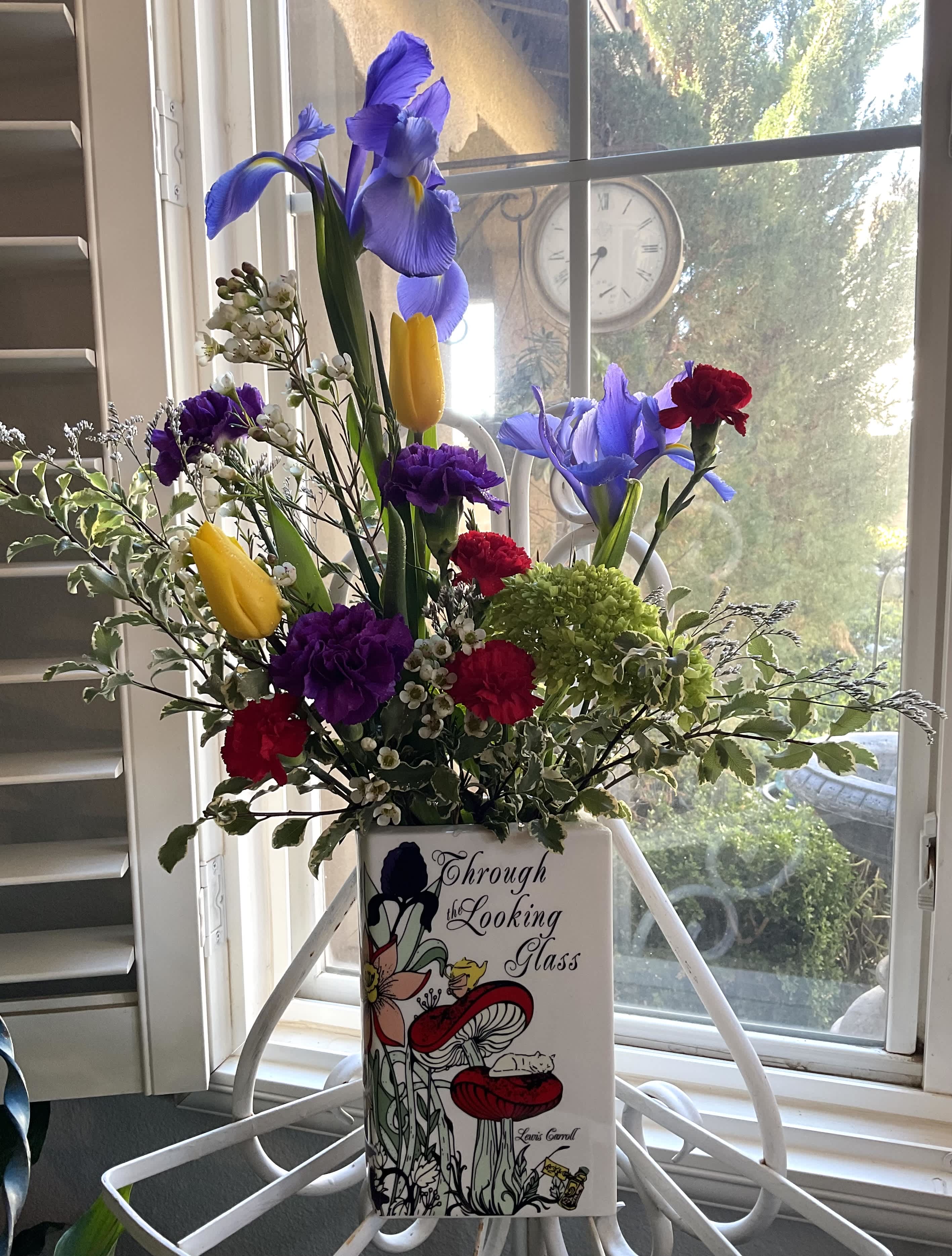 Mixed bouquet in a decorative vase with blue irises and yellow tulips