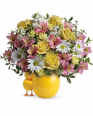 Yellow roses and pink flowers arranged in a yellow vase with a small chick figurine
