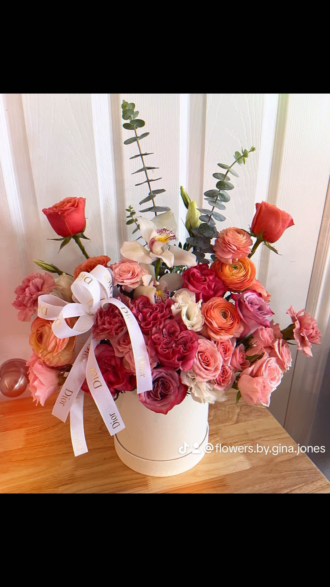 Pink and coral rose bouquet in a white hat box with a ribbon bow