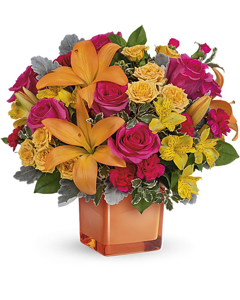 Bouquet of orange lilies, pink roses, and yellow flowers in an orange vase
