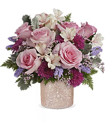 Pink roses and purple flowers arranged in a glittery vase