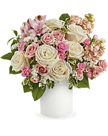 Pink and white roses arranged in a white vase