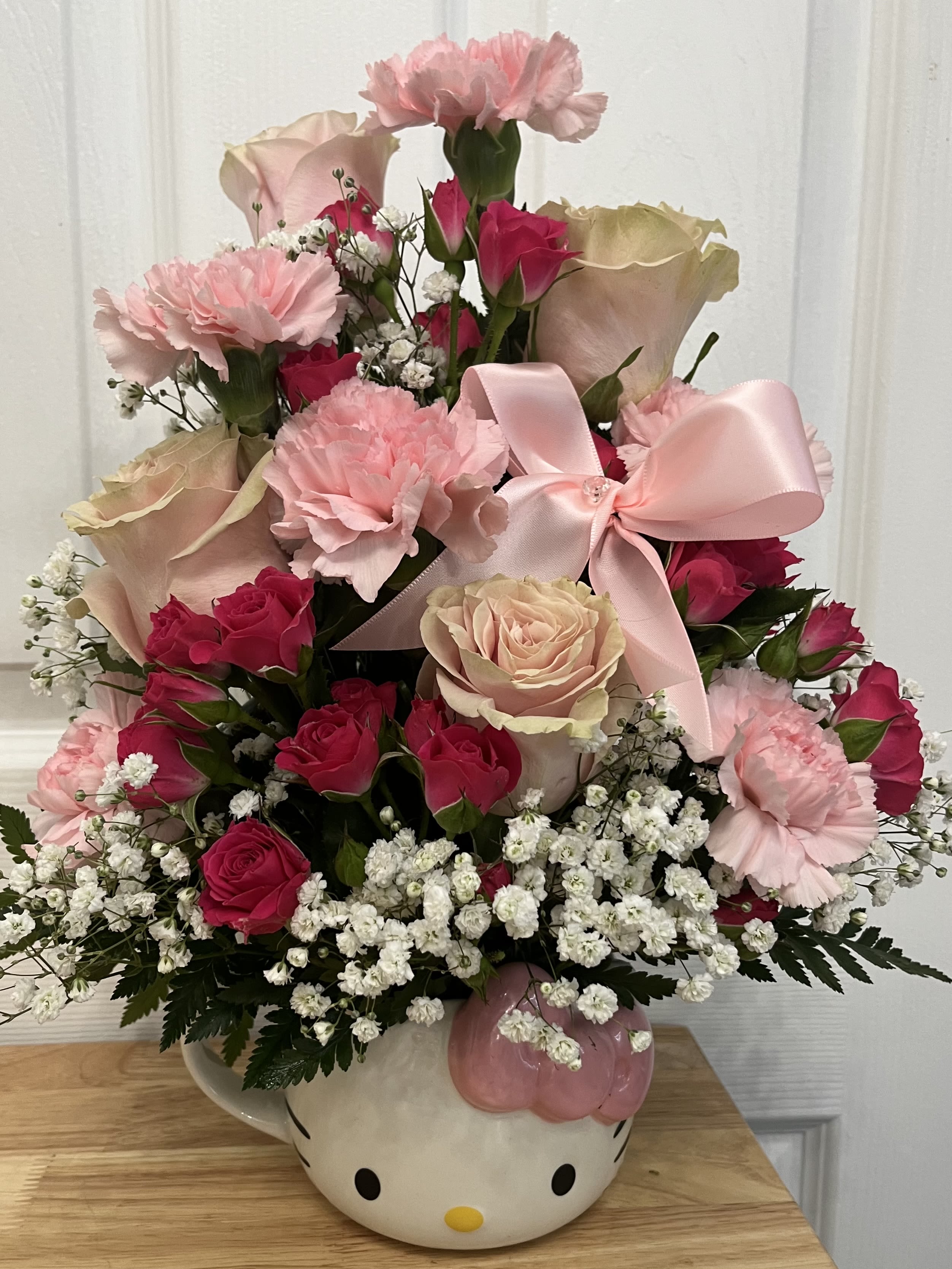 Pink and cream rose bouquet in a Hello Kitty vase with a satin bow