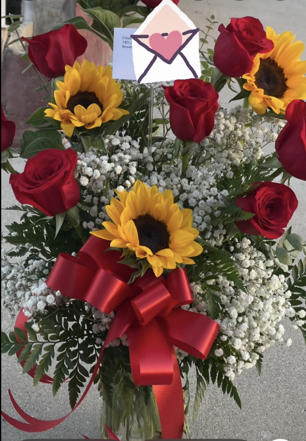 Bouquet of red roses and sunflowers with a red ribbon