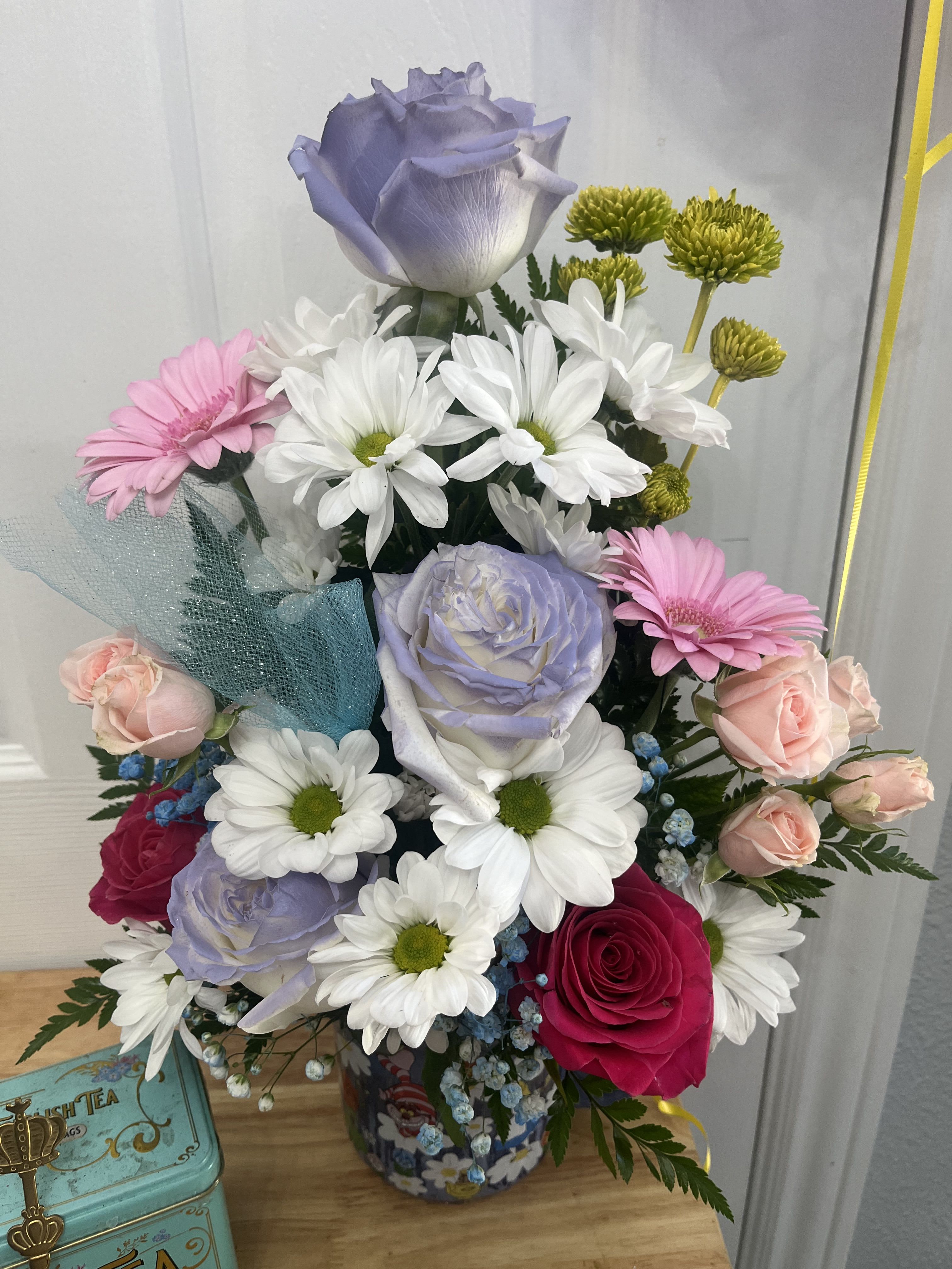 Mixed bouquet with lavender, pink, and white flowers in a decorative container