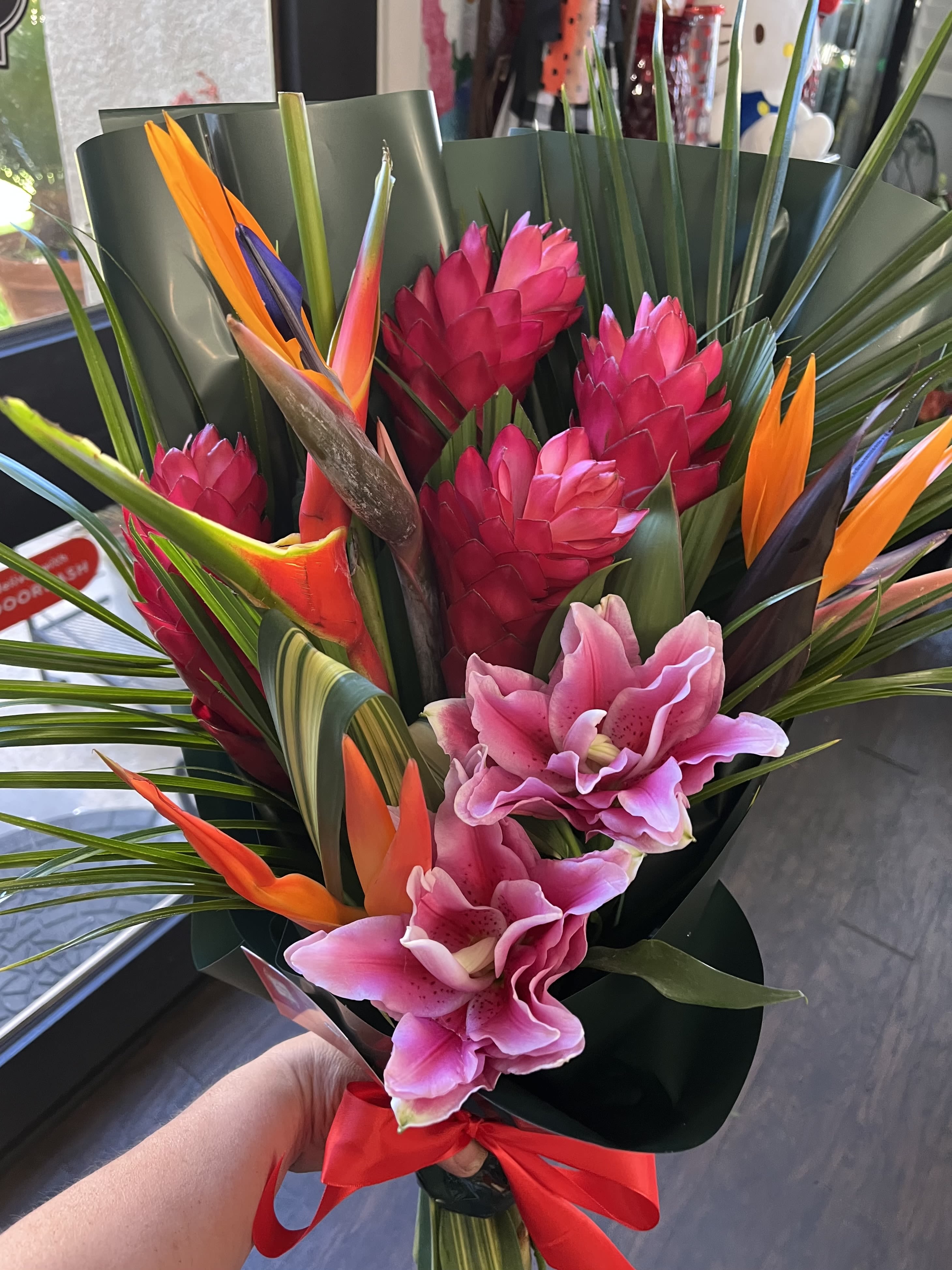 Tropical bouquet with pink orchids and orange bird-of-paradise flowers
