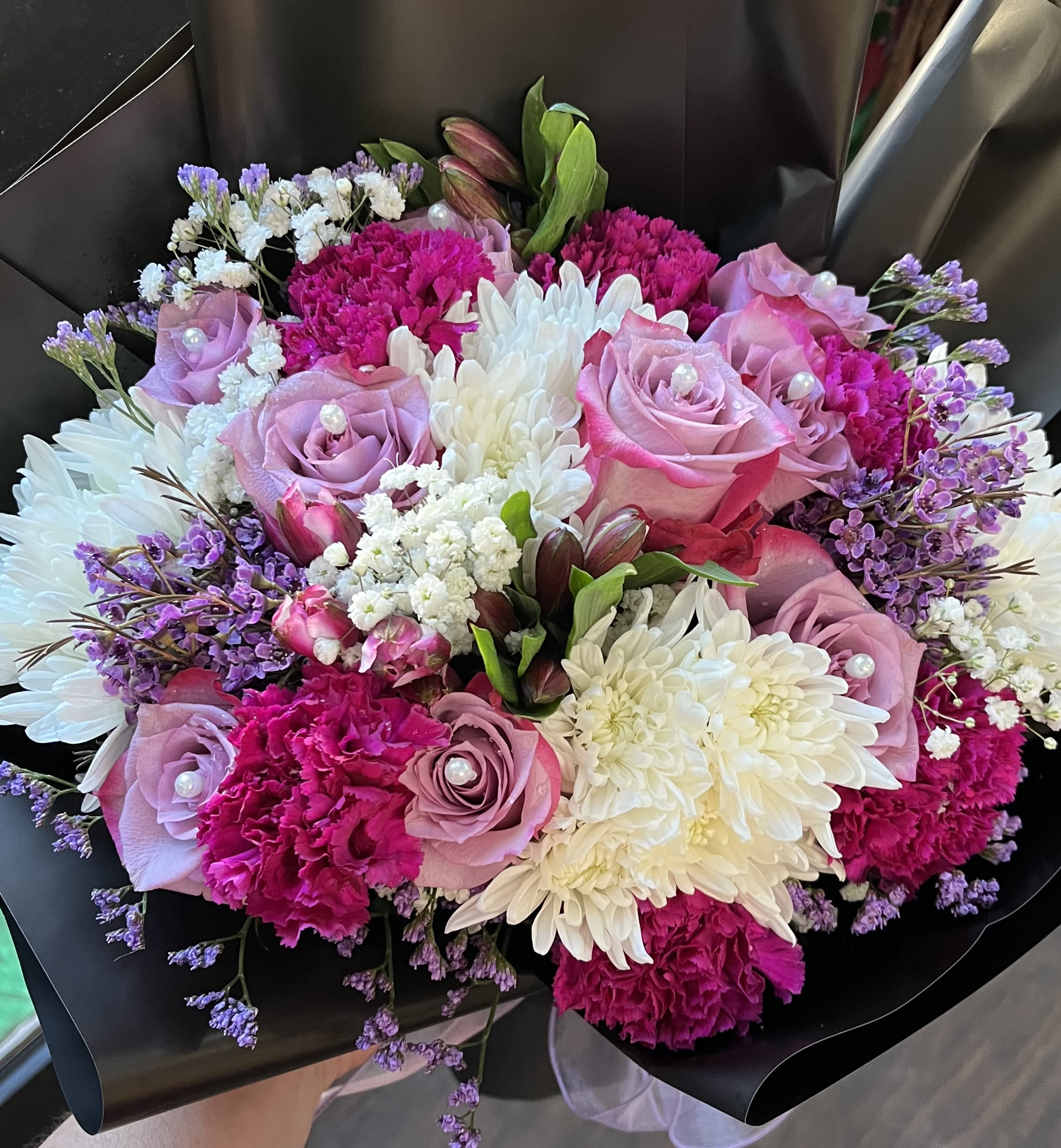 Bouquet of pink roses, white chrysanthemums, and purple filler flowers