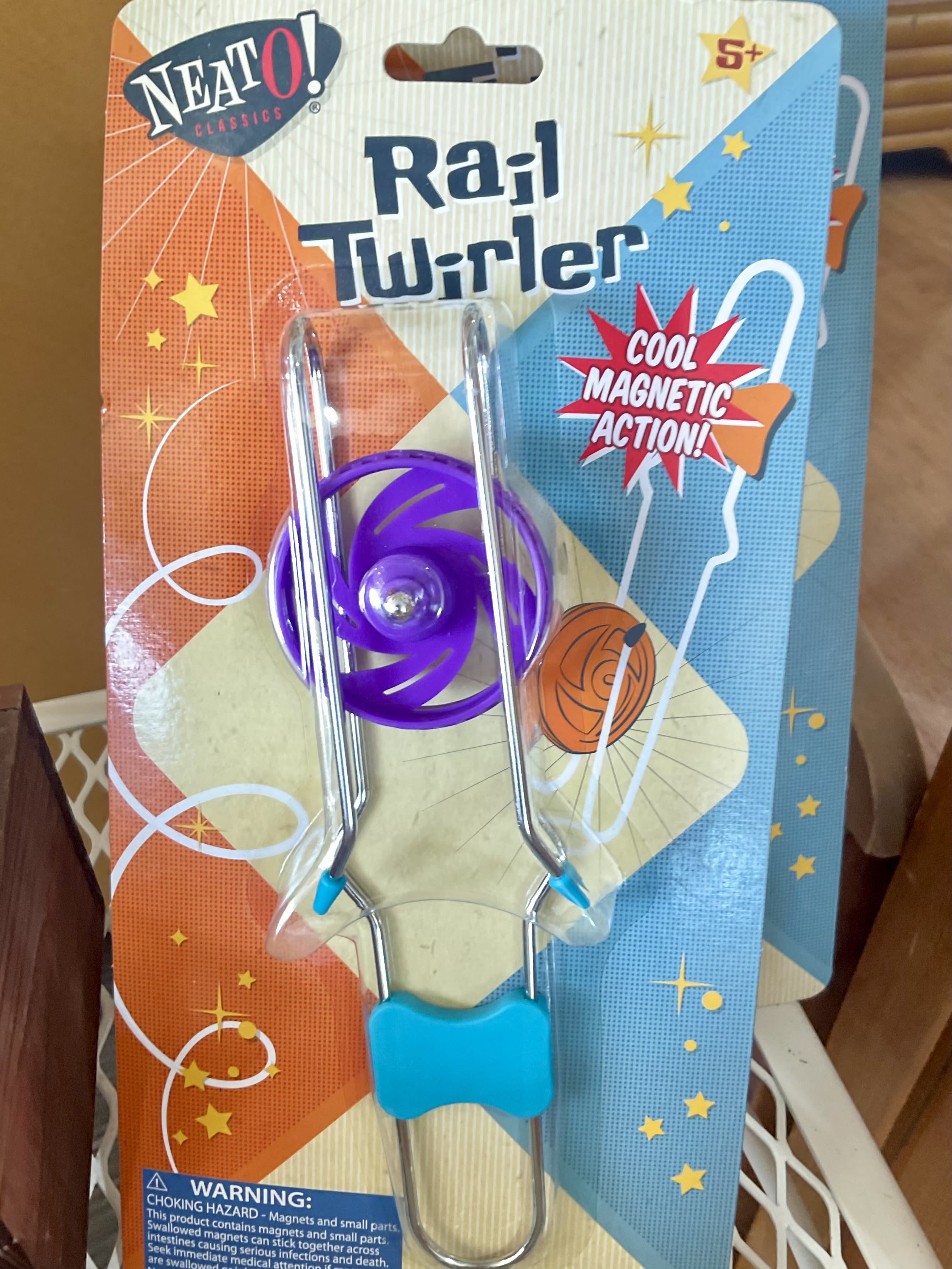 Packaged purple rail twirler toy with metal rods and blue handle