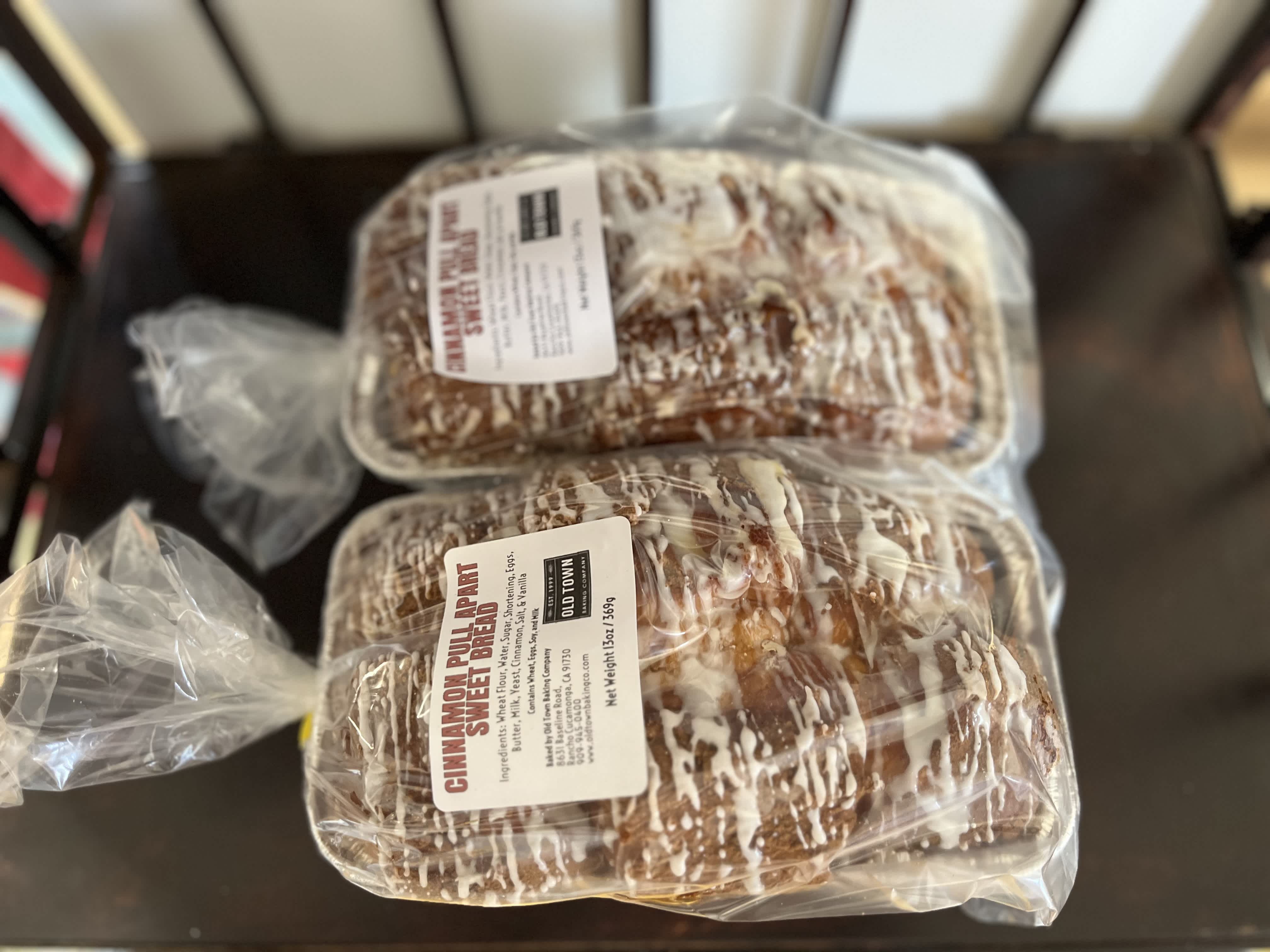 Two packaged loaves of cinnamon pull-apart sweet bread on a table.