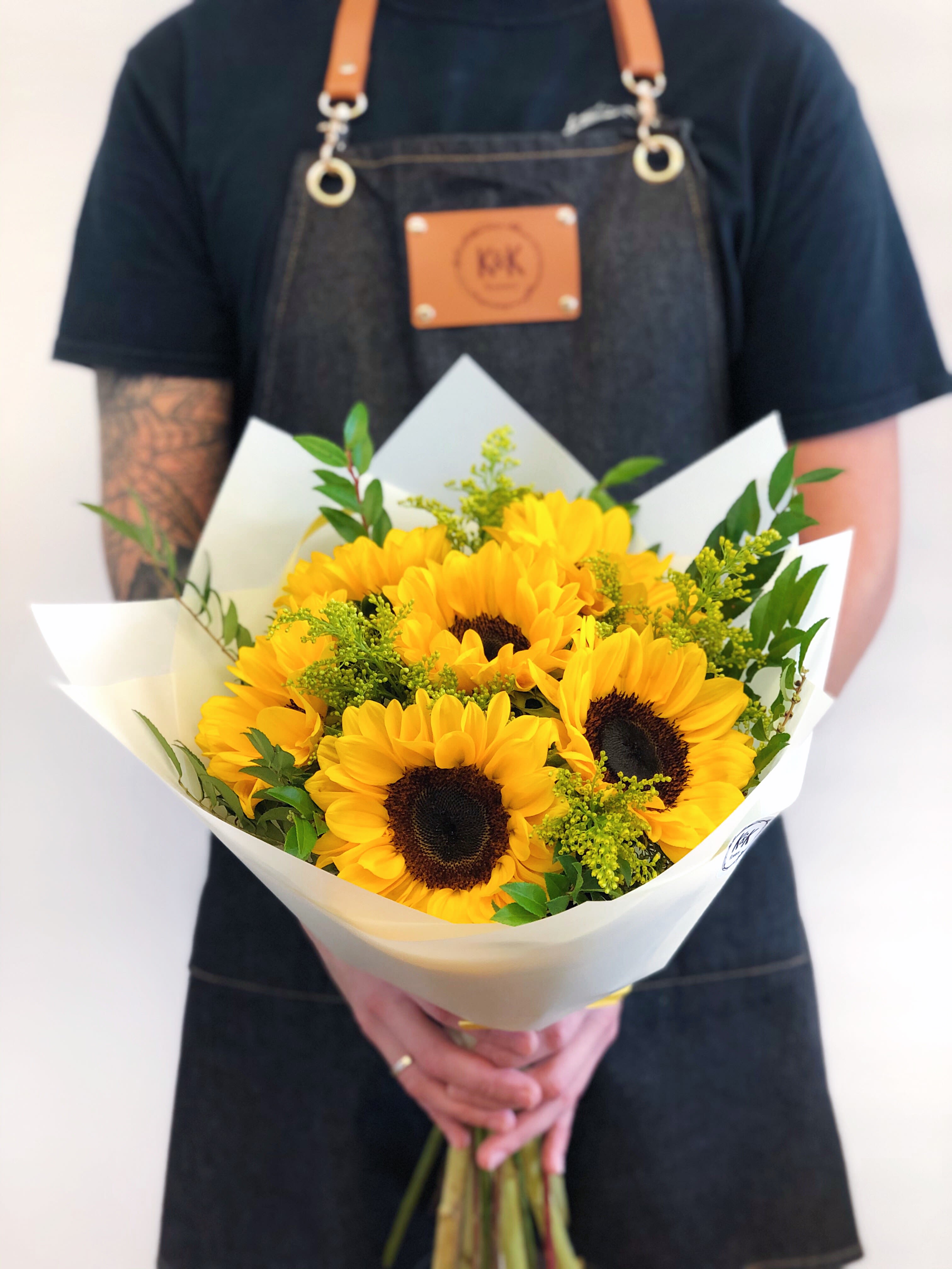 Bouquet of yellow sunflowers wrapped in white paper