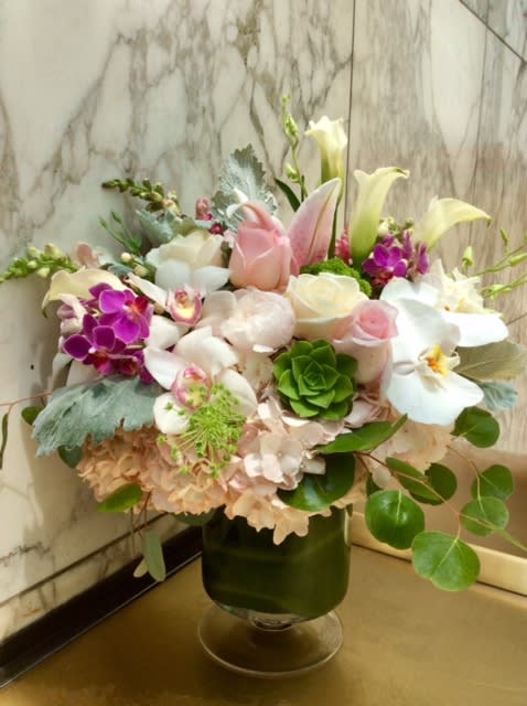 Mixed bouquet of white, pink, and purple flowers in a glass vase