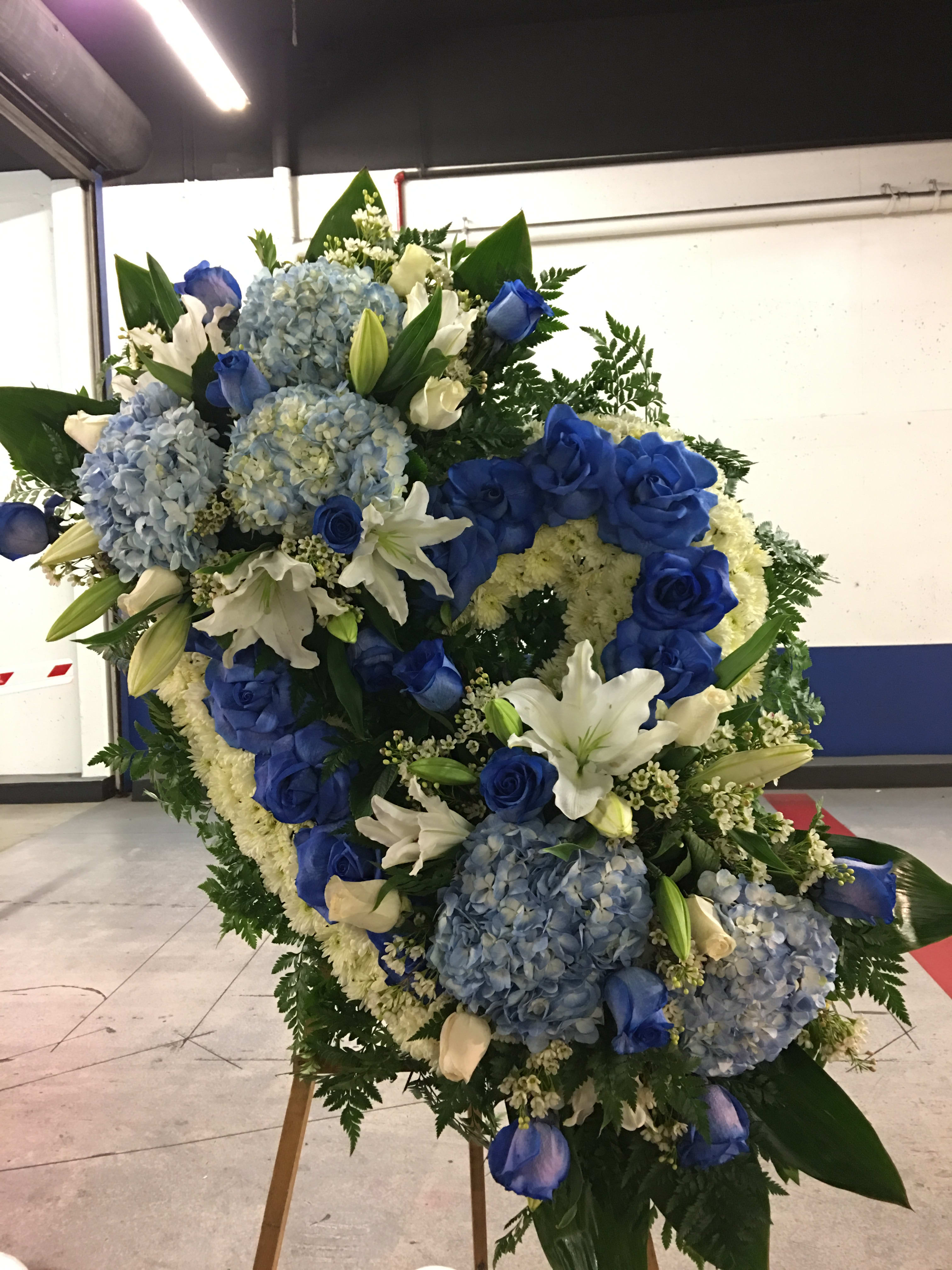 Large blue and white floral standing spray with roses, lilies, and hydrangeas
