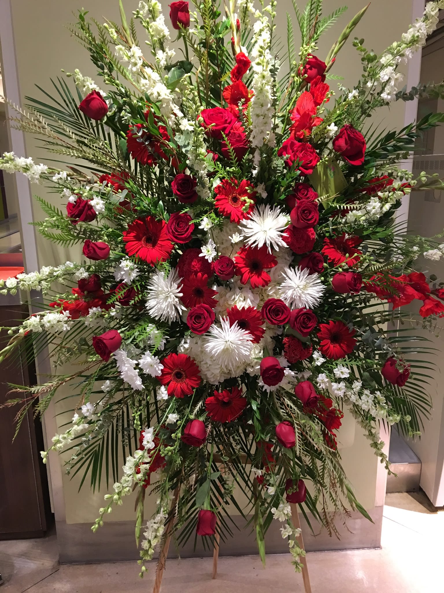 Large red and white floral standing spray with roses and gerbera daisies