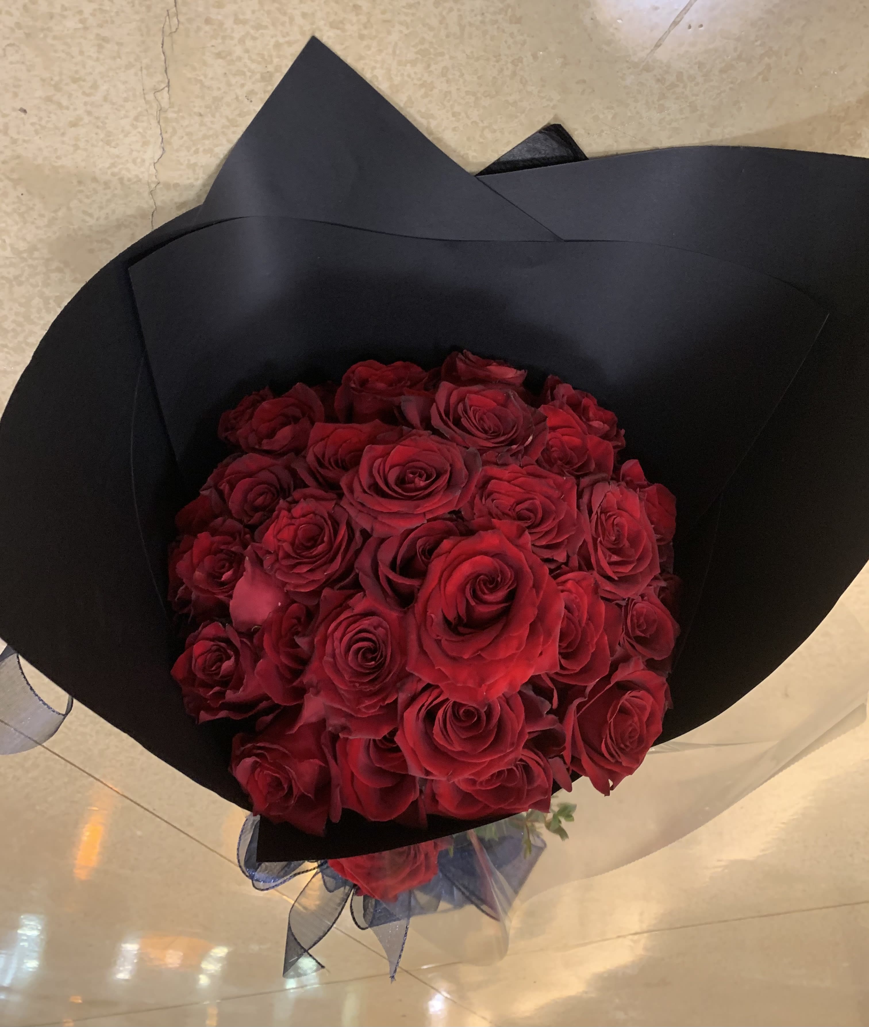 Bouquet of red roses wrapped in black paper