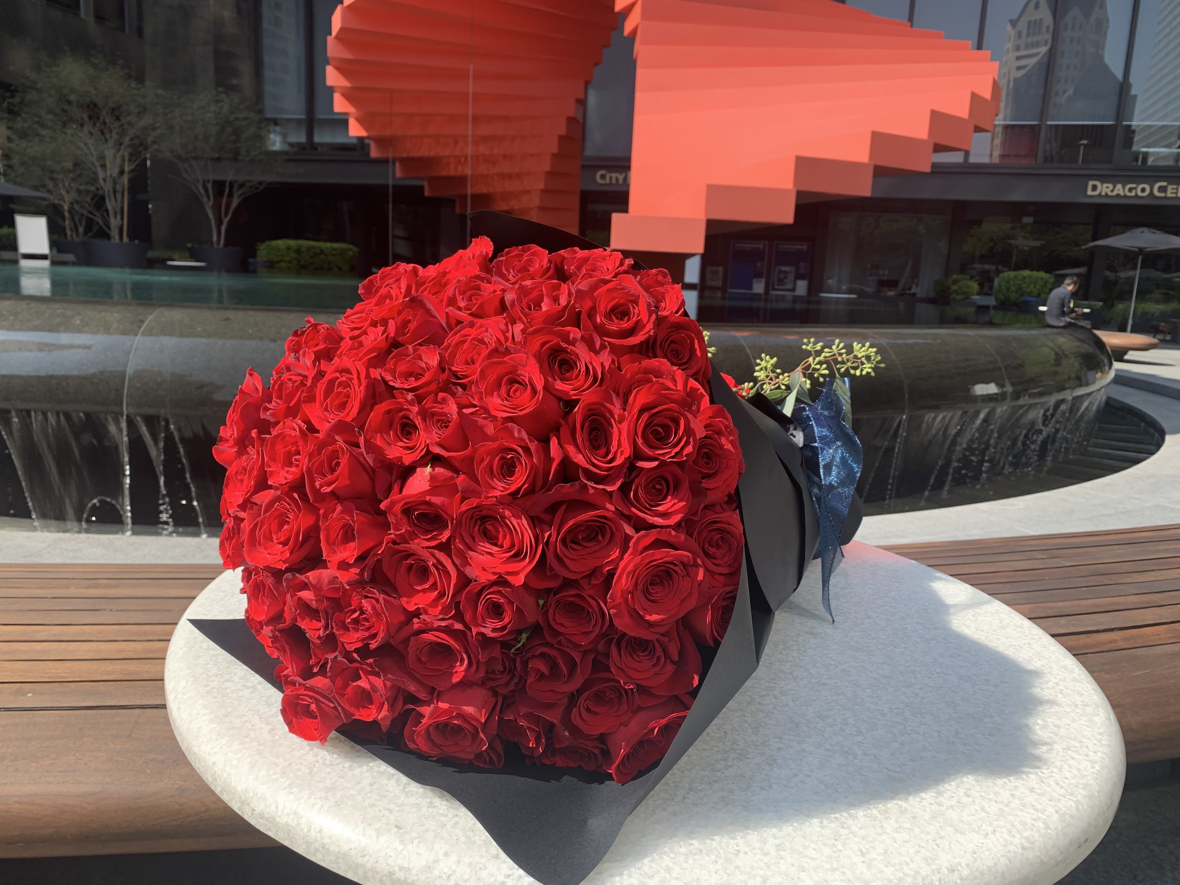 Large bouquet of red roses wrapped in black paper