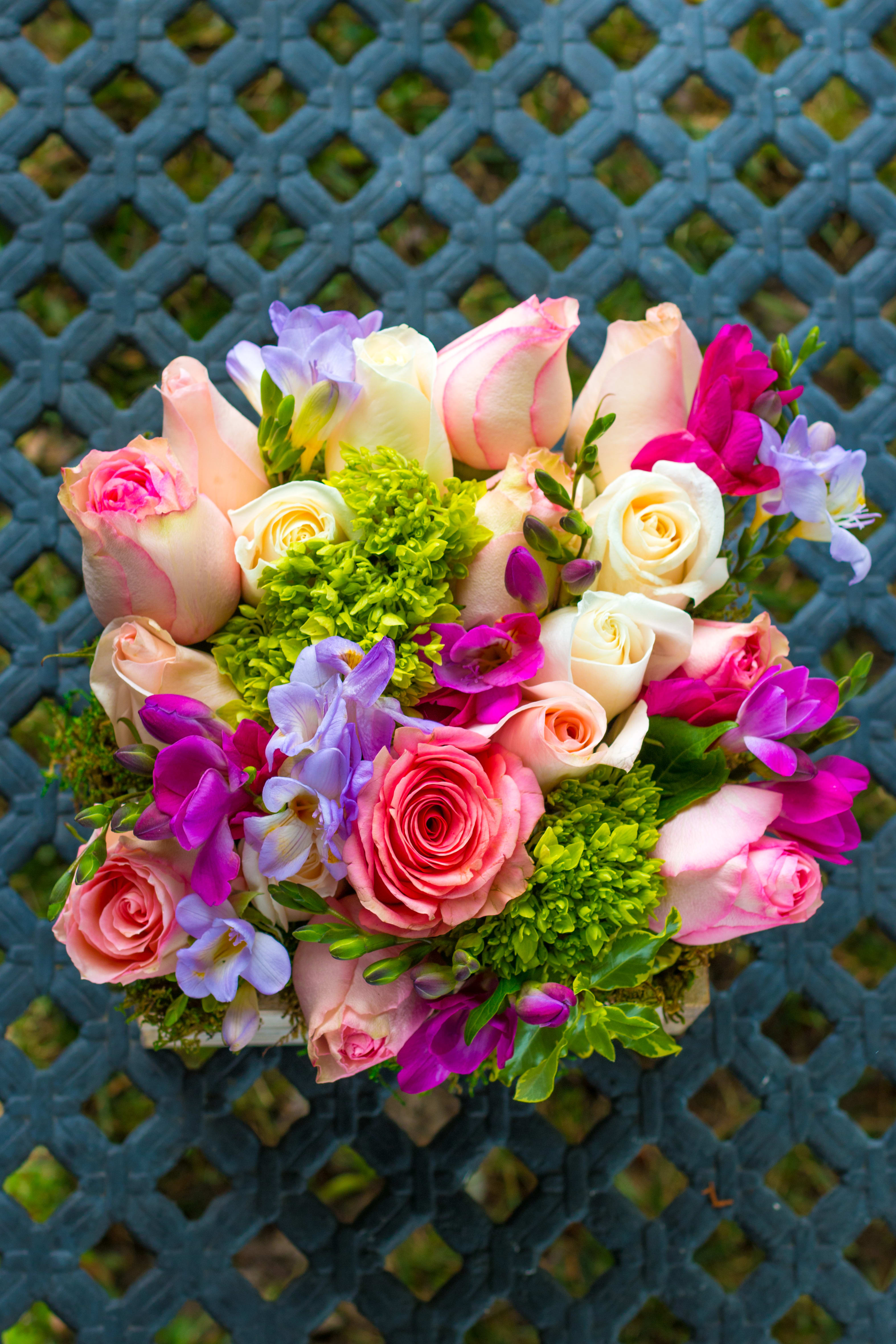 Scatola di Primavera - Experience the vibrant beauty of spring with this stunning 360-degree arrangement in a 10-inch wooden box. Featuring a perfect combination of blush pink roses, peach roses, mini green hydrangeas, gorgeous freesias, and more, this arrangement is sure to wow your special someone. Each bloom is carefully selected and expertly arranged to create a harmonious blend of colors and textures that wrap together elegantly. Ideal for celebrating any occasion or brightening any space with the essence of spring. Order now to delight your loved one with this captivating floral masterpiece!
