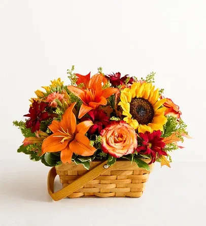 Basket arrangement with orange lilies, sunflowers, and red flowers