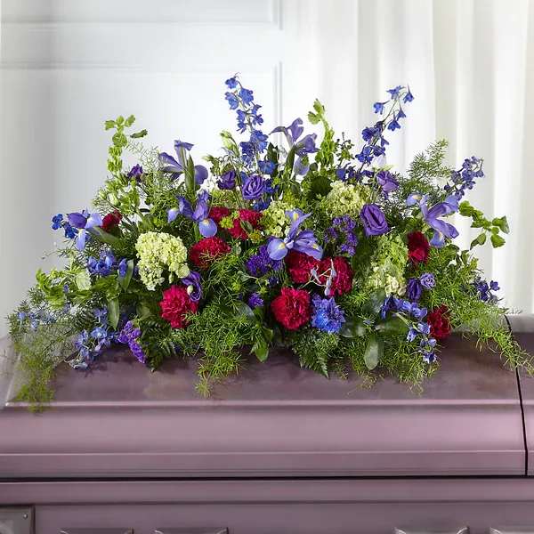 Large casket spray with blue, purple, pink, and white flowers