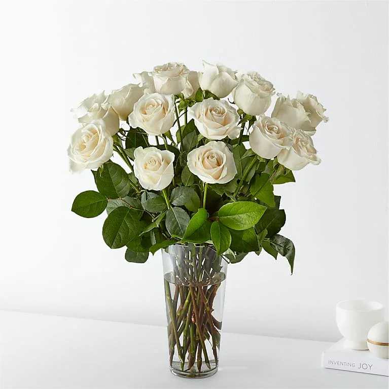 White roses arranged in a clear glass vase