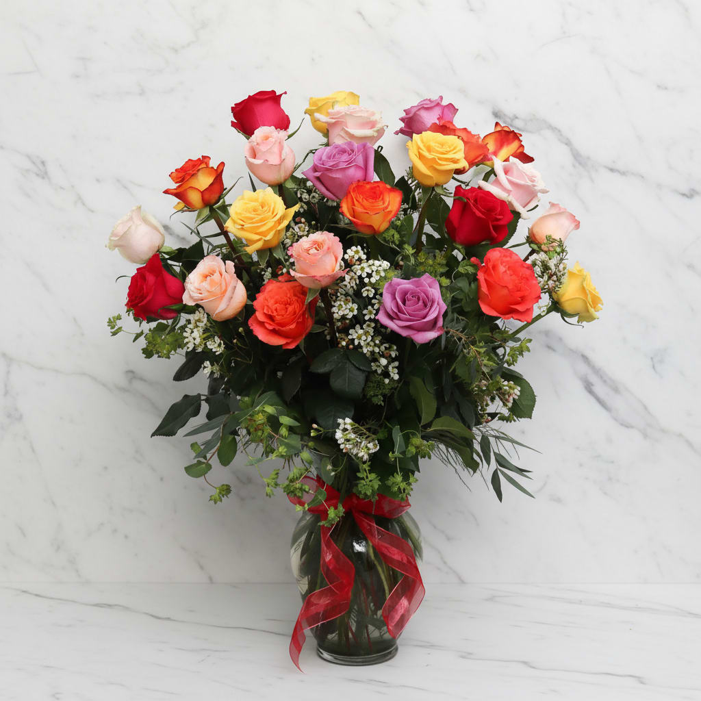 Colorful rose bouquet in a glass vase with a red ribbon