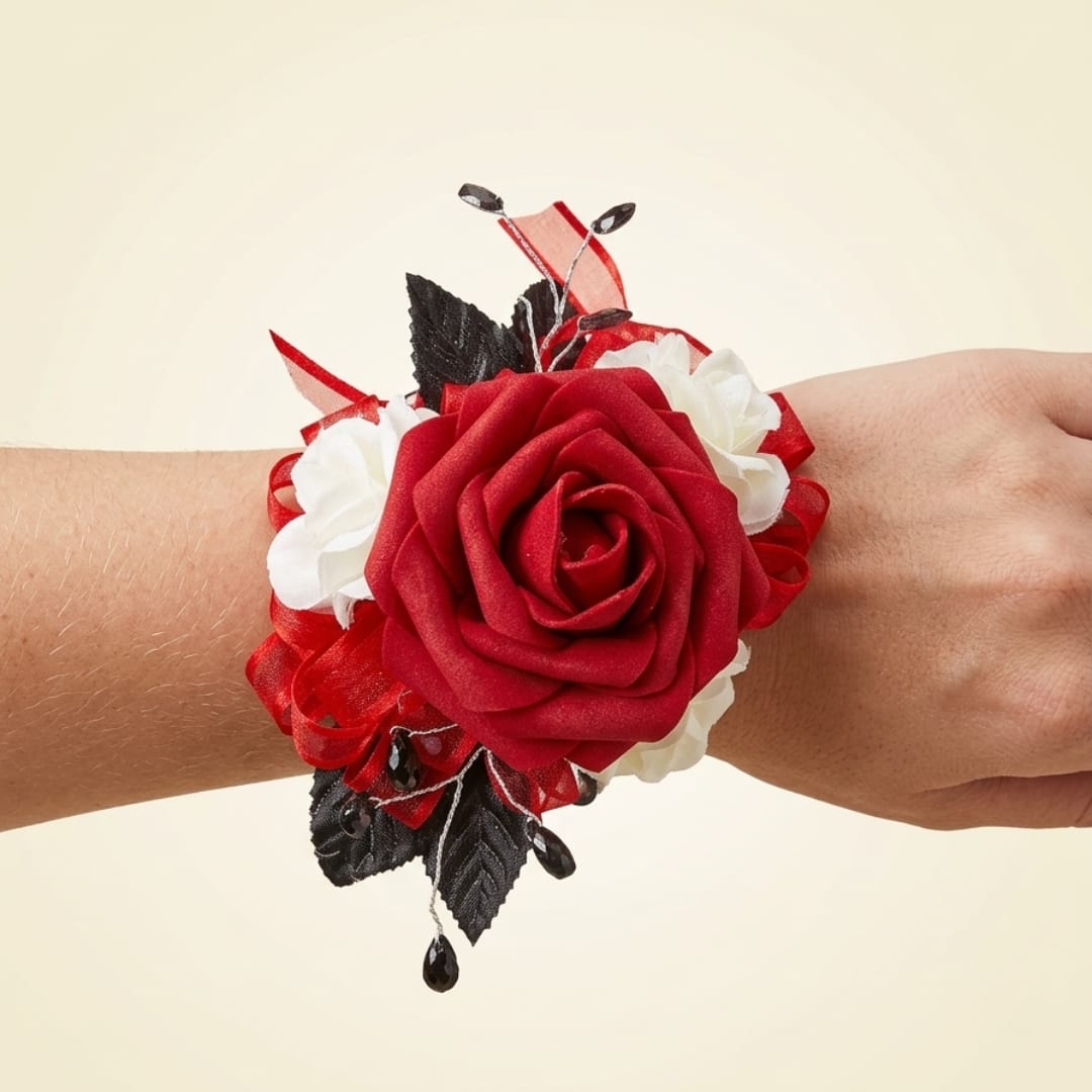 Red rose wrist corsage with white accents on a person's wrist