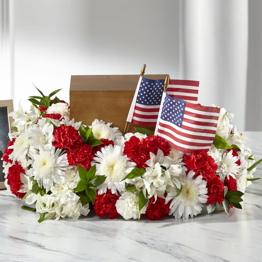 Red and white floral arrangement with two small American flags