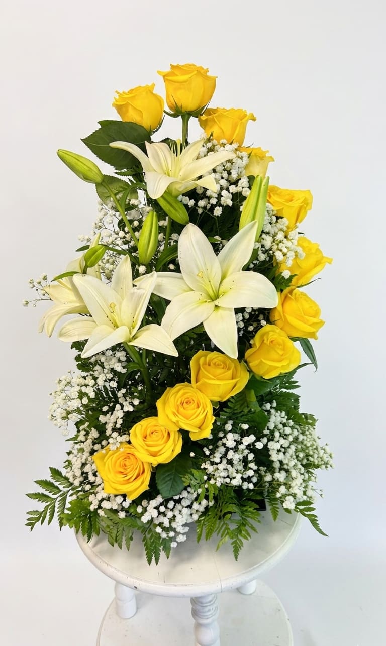 Sunlit Ascent - Dramatic design meets vibrant color in this stunning, high-style arrangement. Featuring a sweeping, cascading wave of premium yellow roses that flows seamlessly alongside magnificent white lilies, this vertical masterpiece is engineered to capture attention. Accented with clouds of baby’s breath and architectural greenery, it’s a brilliant choice for modern spaces, elegant galas, or a grand celebratory gesture.