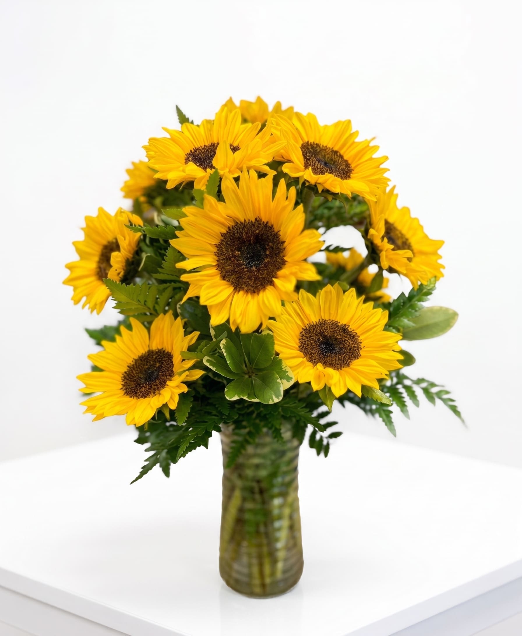 Sunflower Bouquet - Brighten up a table, send get well wishes, or simply sprinkle sunshine on someone's day with this beautiful flower arrangement. Bold sunflowers are arranged in a glass vase.