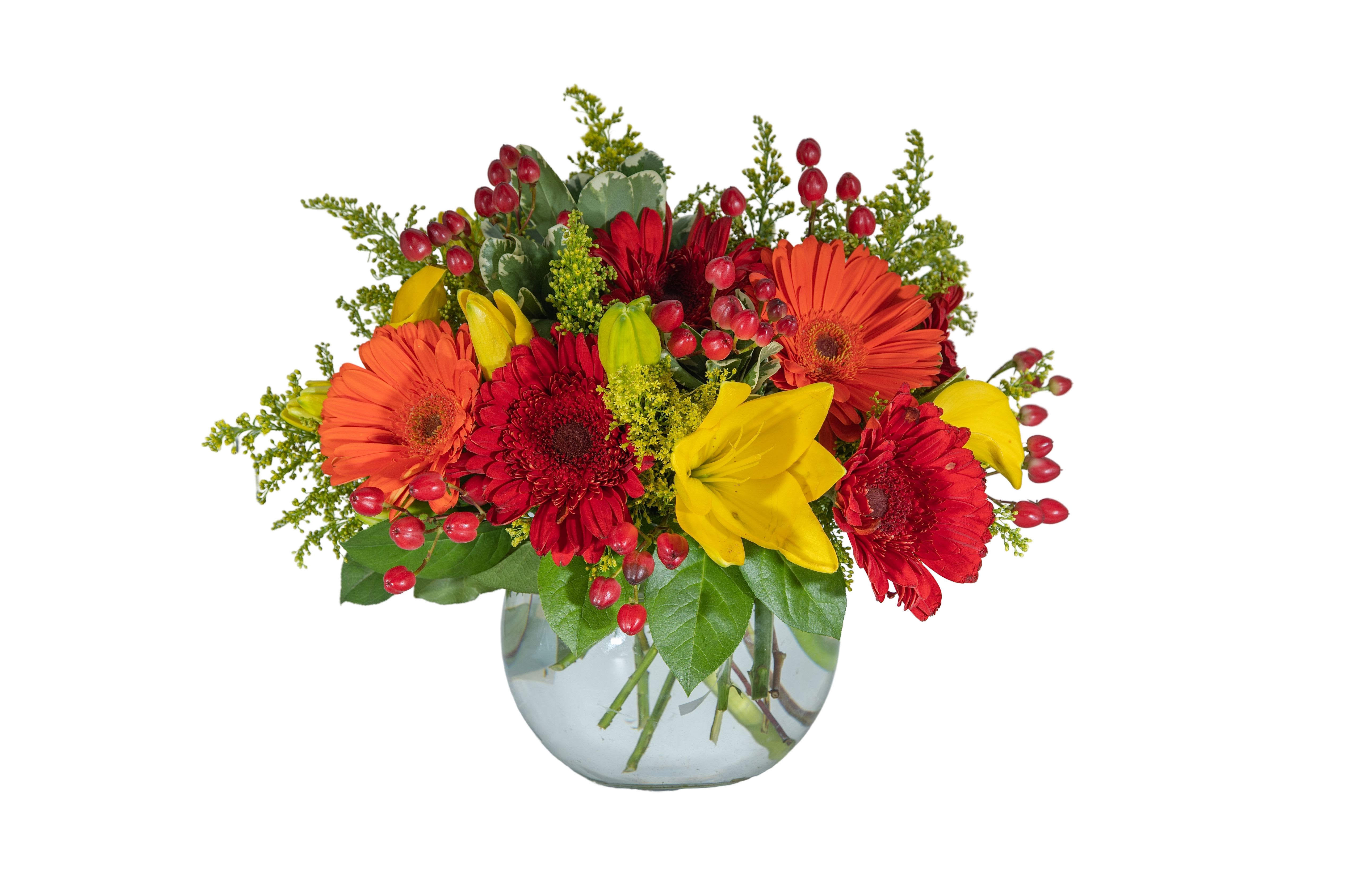 Bright mixed bouquet of red, orange, and yellow flowers in a glass vase