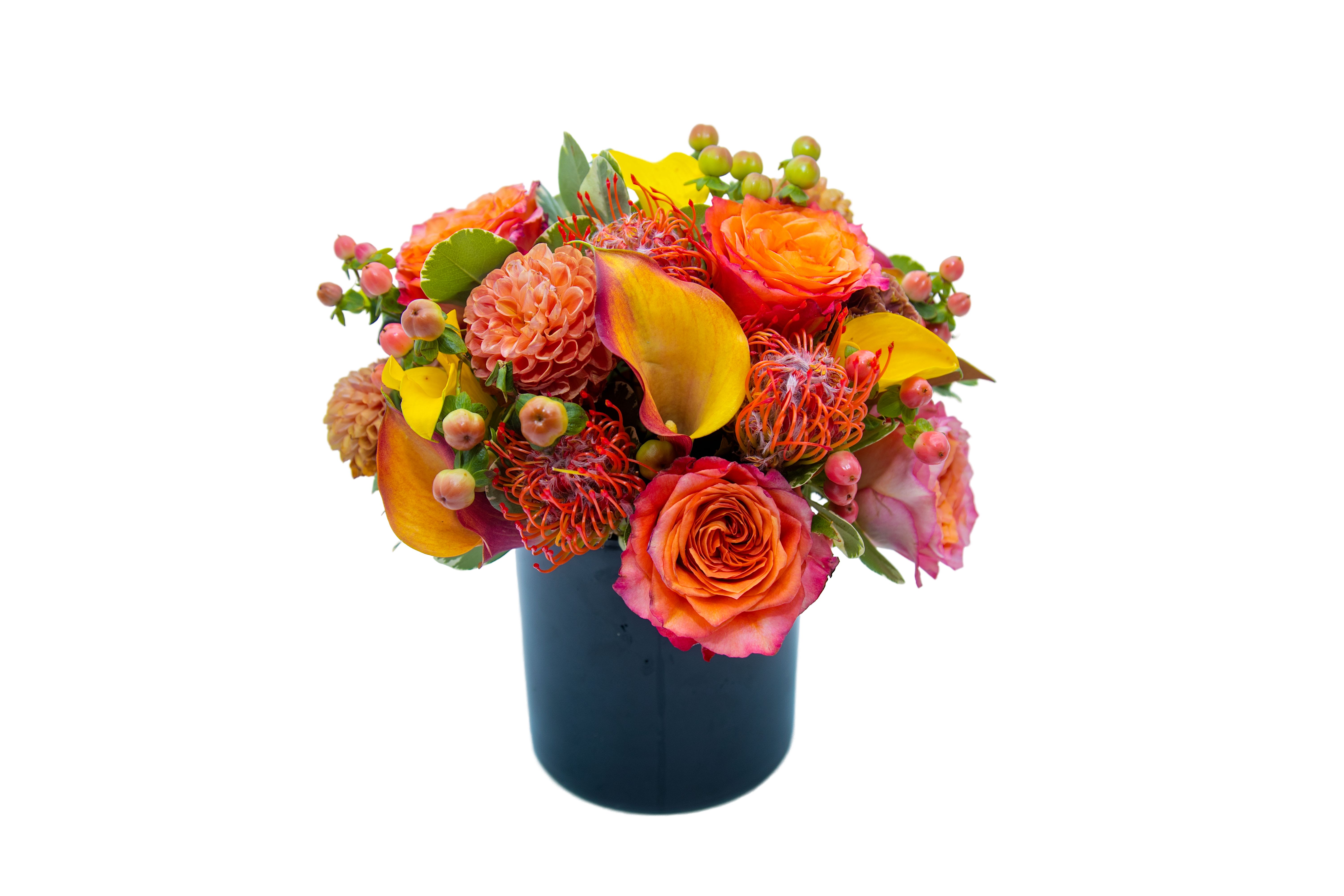 Bright mixed bouquet in a dark vase with orange and yellow blooms