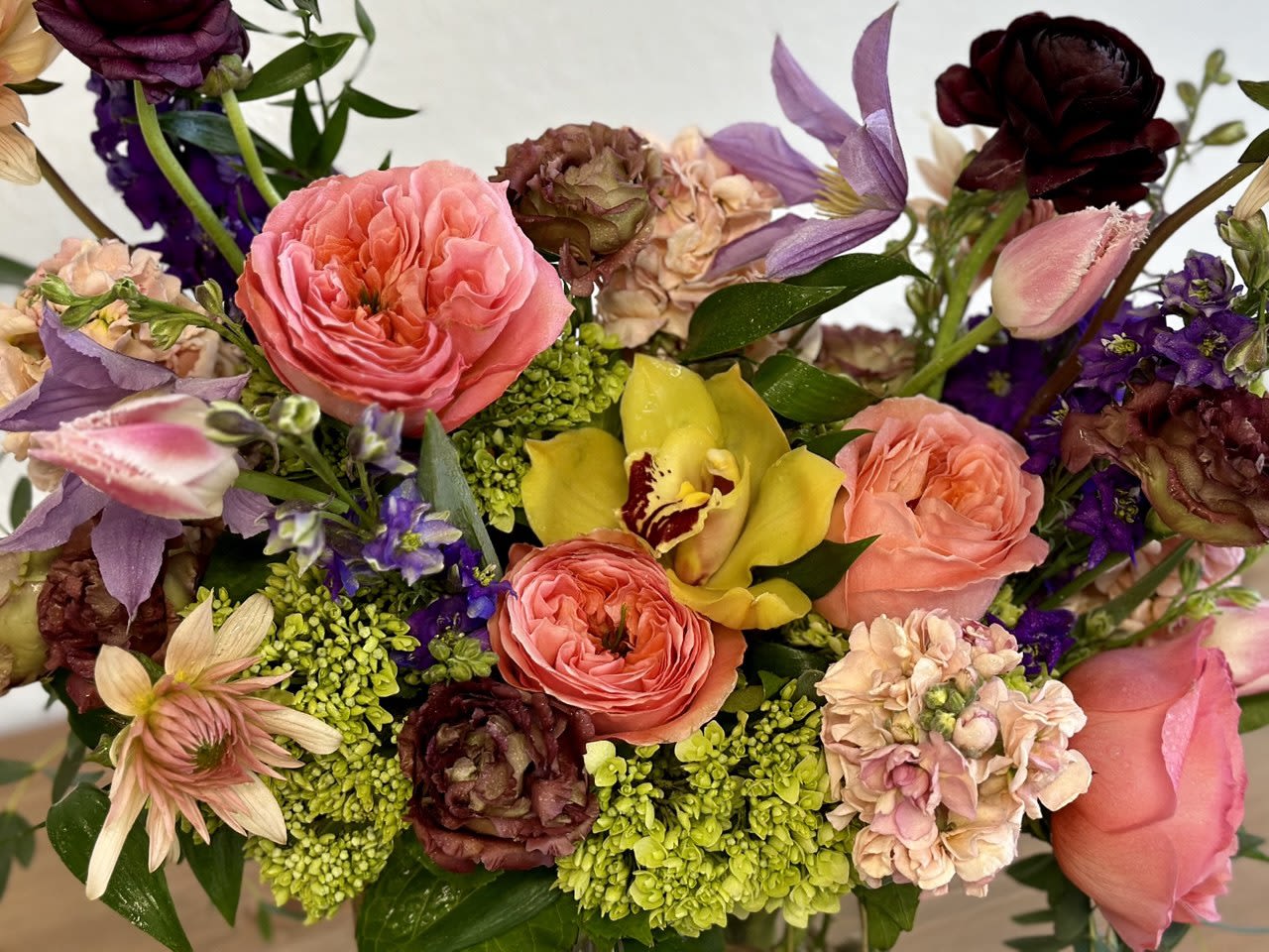 Mixed bouquet with pink roses, purple flowers, and a yellow orchid