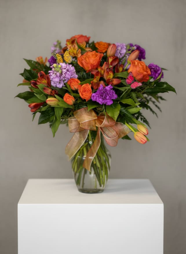 Butterfly Kisses - Assorted flowers in shades of purple and orange, with a butterfly touch