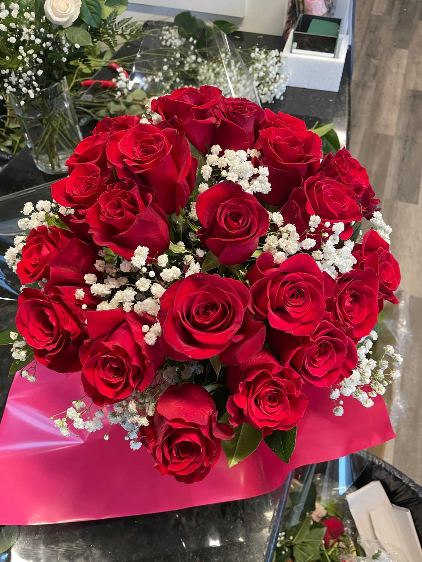Bouquet of red roses with white baby's breath in pink wrap