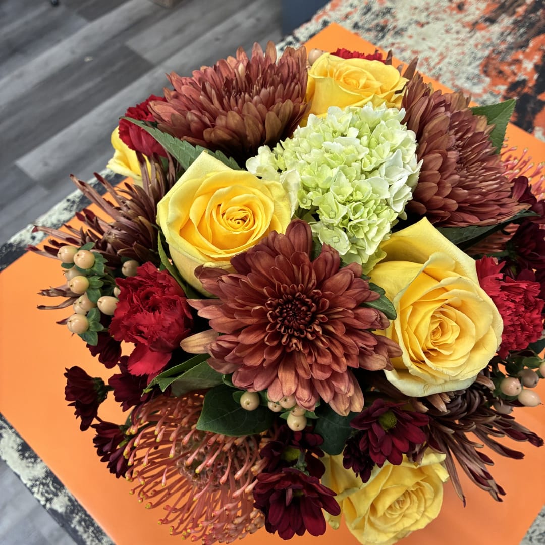 Bouquet of yellow roses, burgundy chrysanthemums, and pale green hydrangea