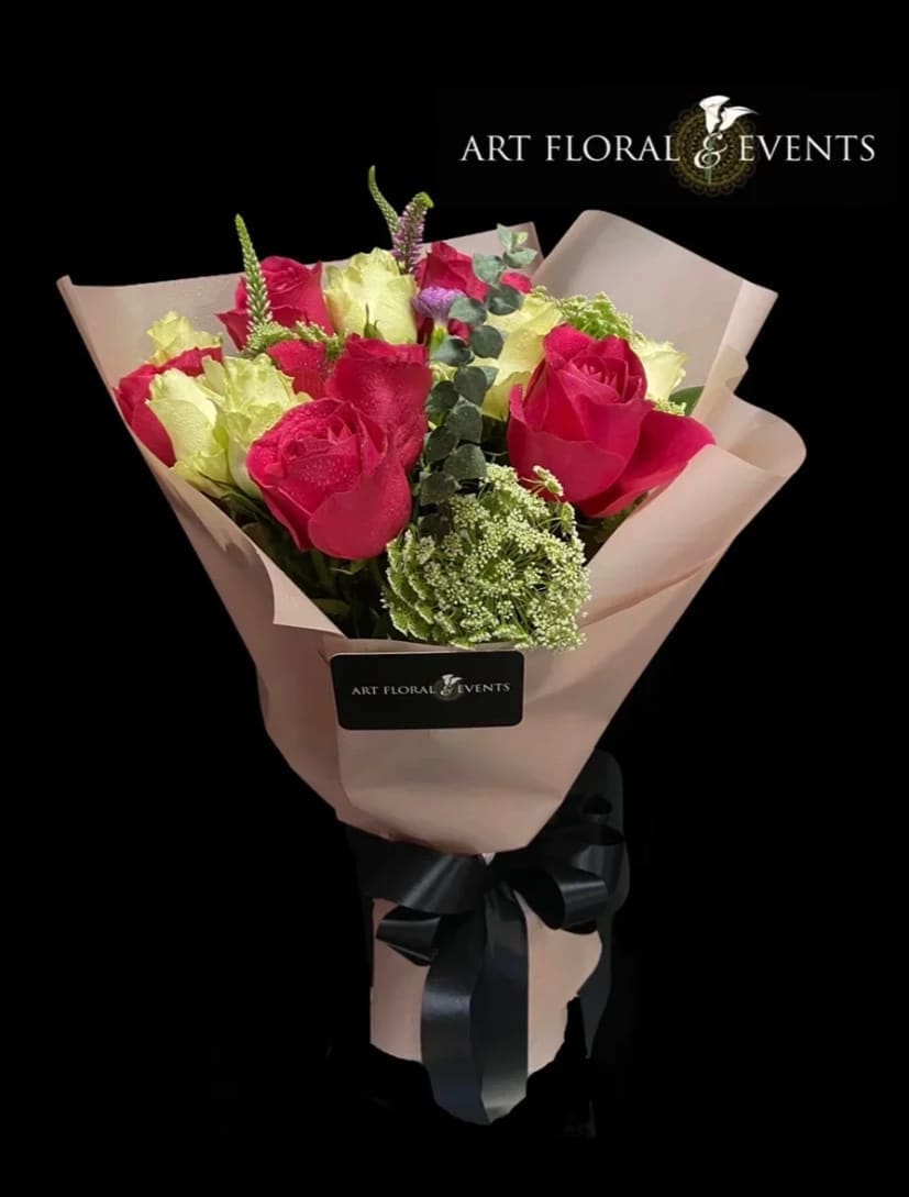 Bouquet of pink and pale yellow roses wrapped in blush paper
