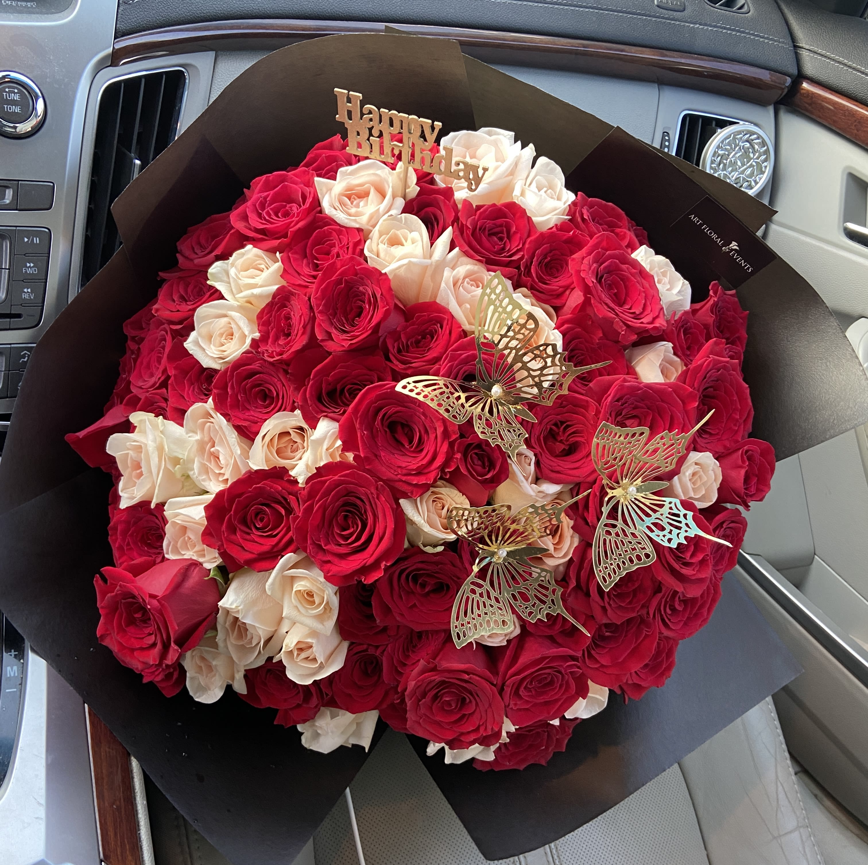 Bouquet of red and blush roses with butterfly picks and a Happy Birthday topper