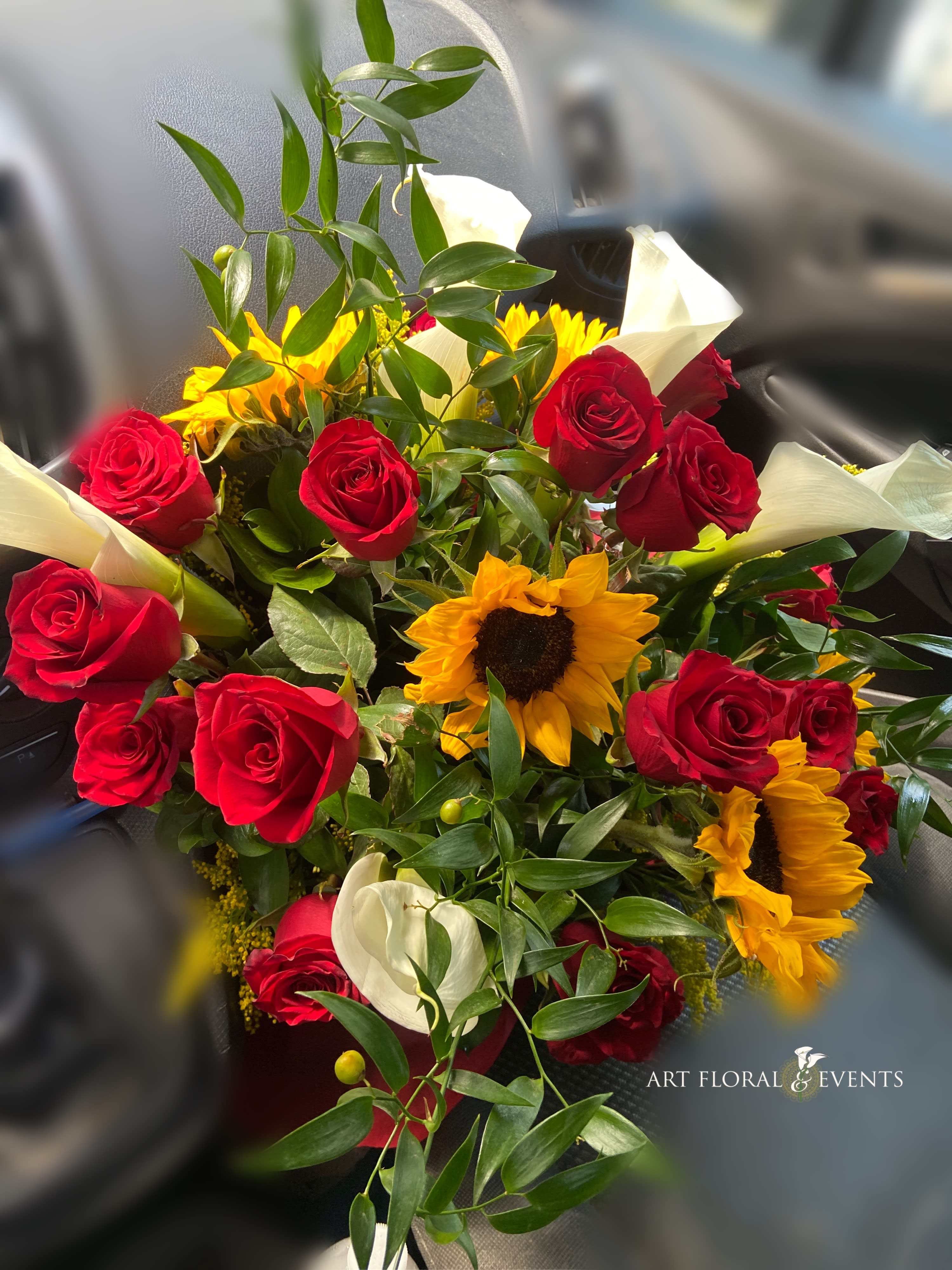 Bouquet of red roses, sunflowers, and white calla lilies