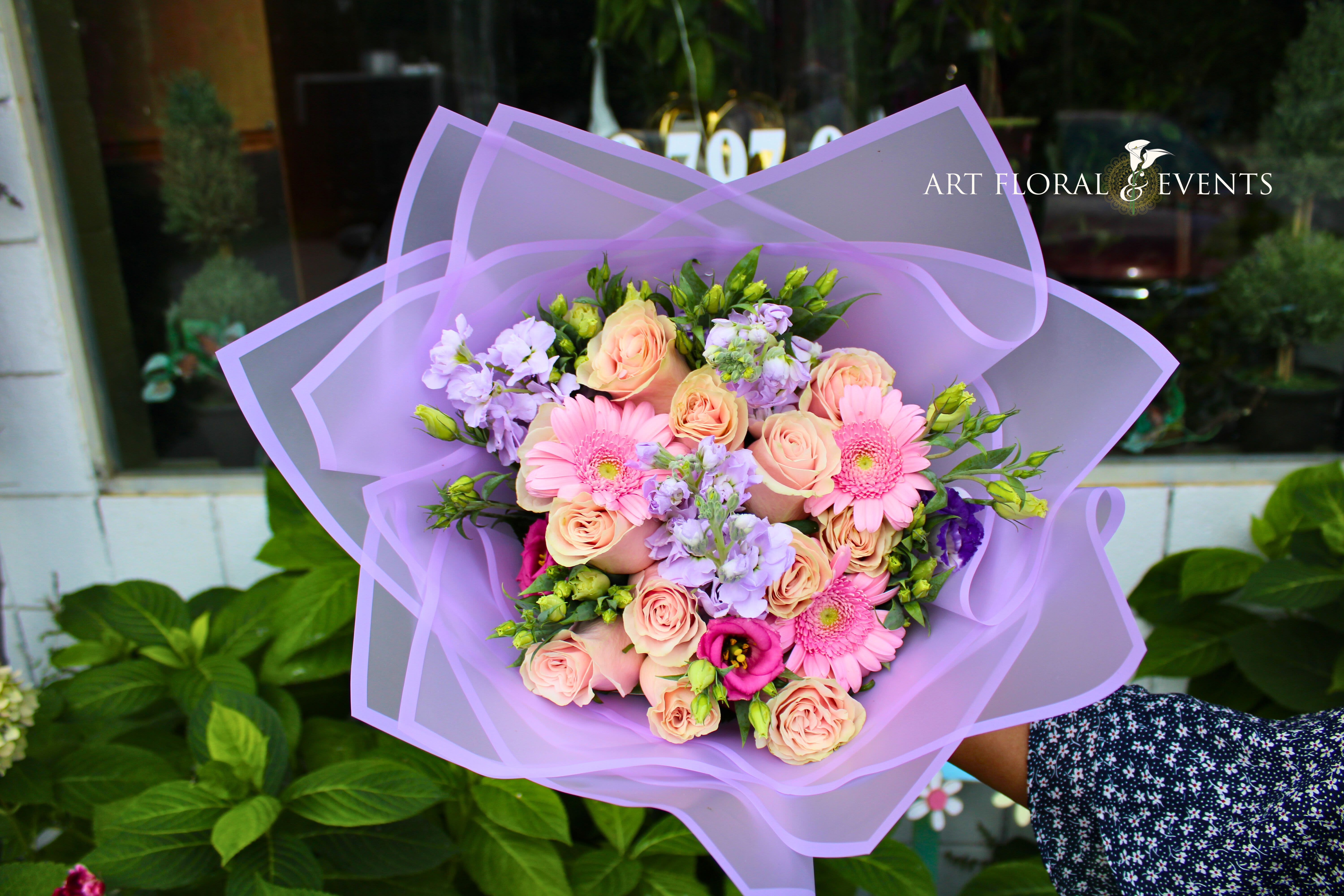Lavender-wrapped bouquet of pink roses and gerbera daisies