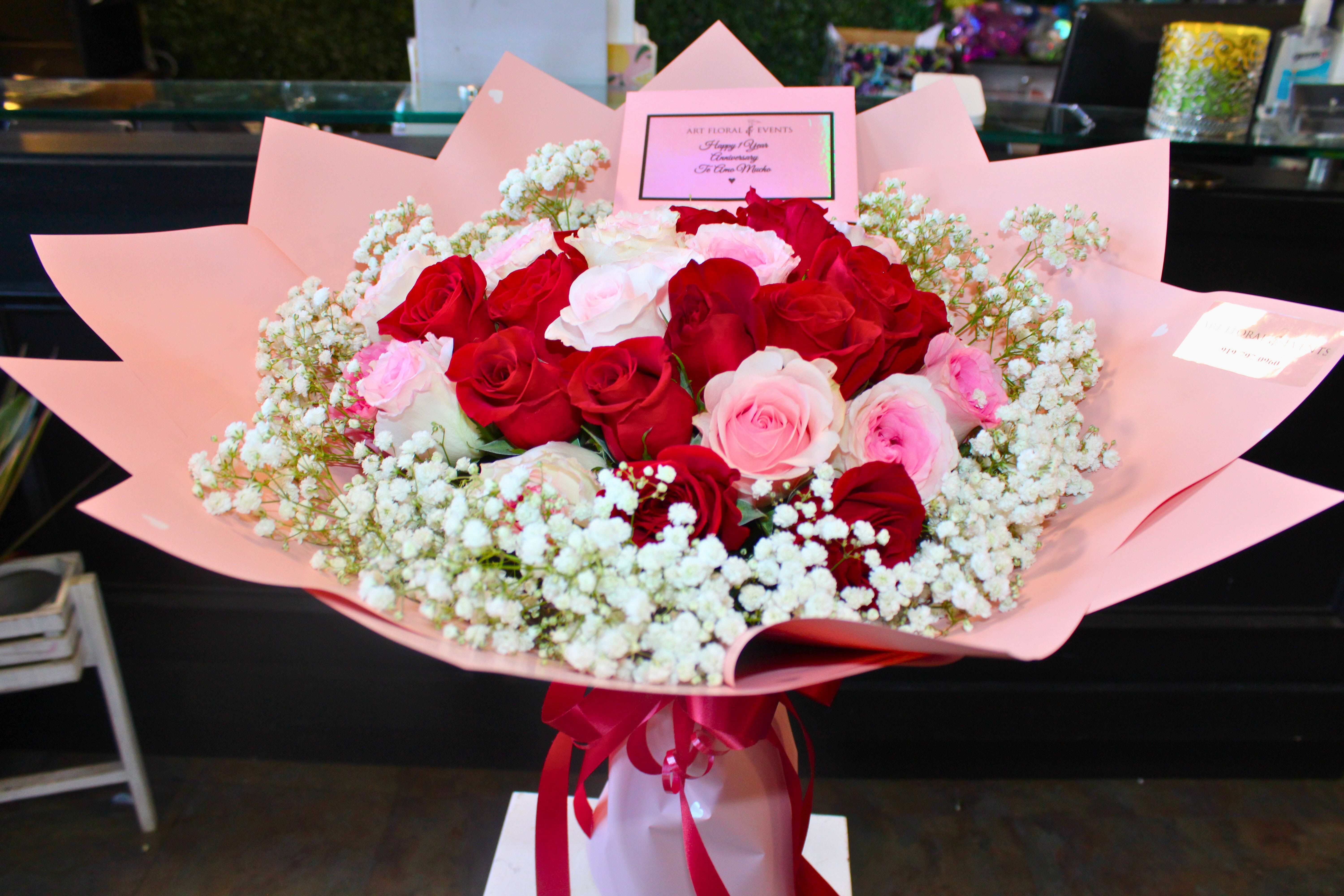 Bouquet of red and pink roses wrapped in pink paper