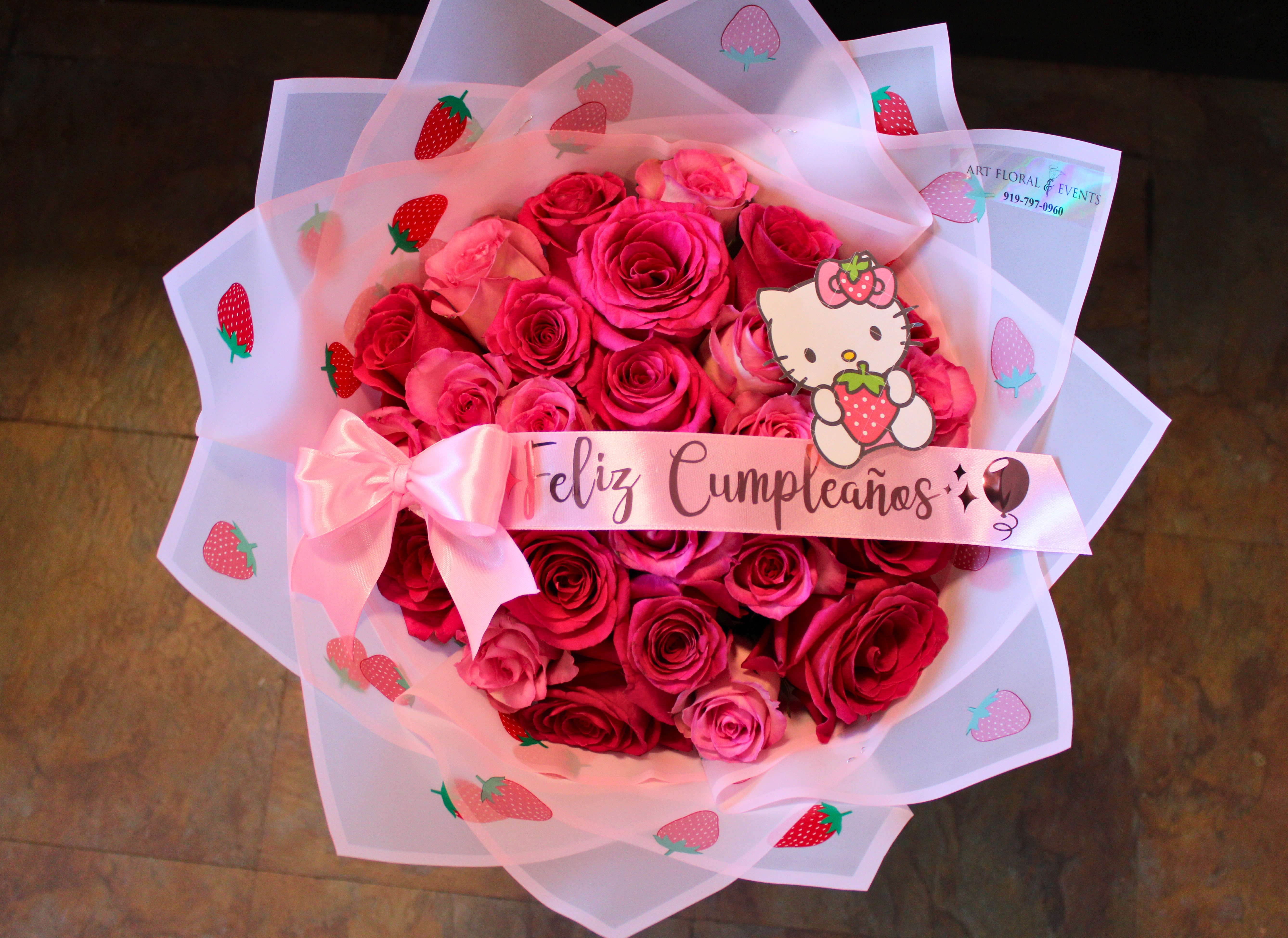 Pink rose bouquet wrapped in strawberry-printed paper with a birthday ribbon