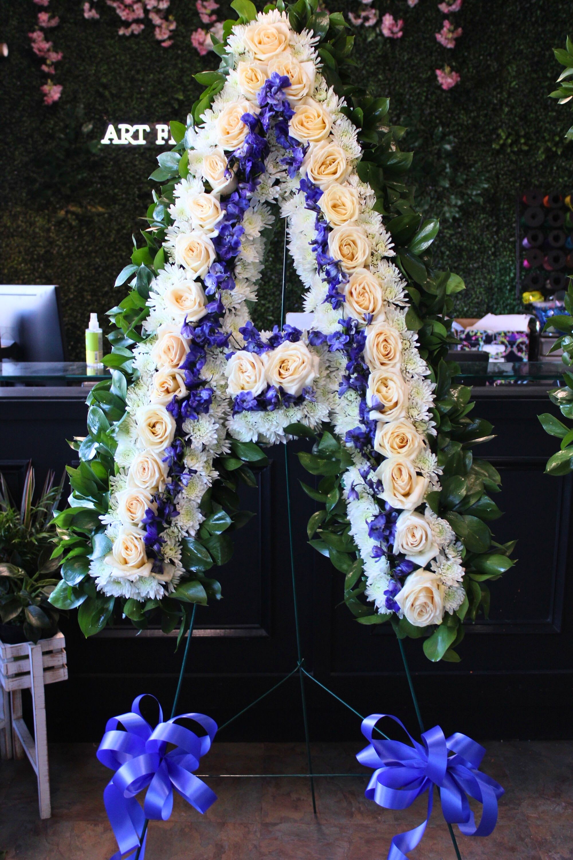 Large floral letter A on a stand with cream roses and purple flowers