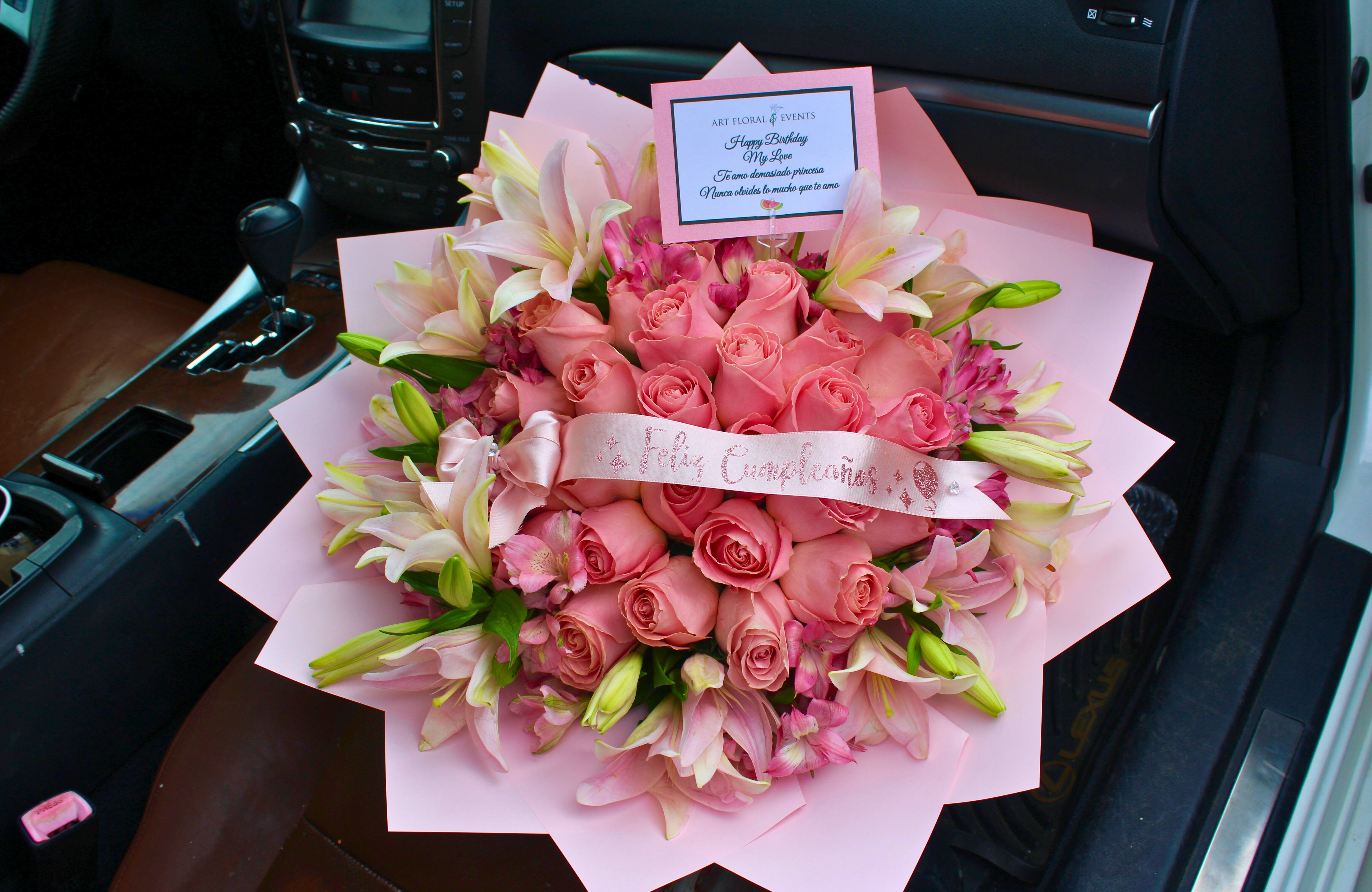 Pink rose bouquet with lilies and a birthday card in a car seat