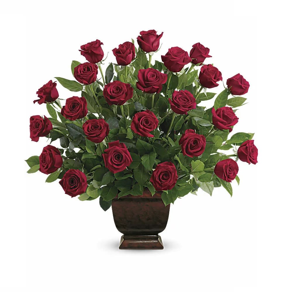 Red roses arranged in a dark pedestal vase