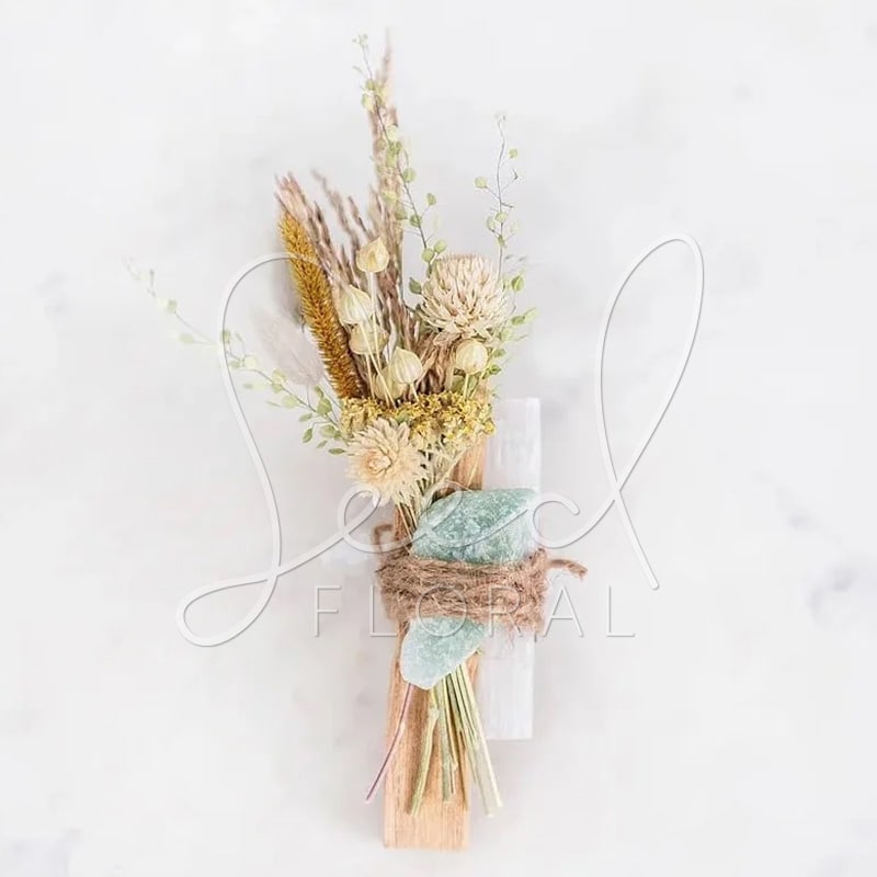 Dried floral bouquet with pale blooms and grasses tied with twine