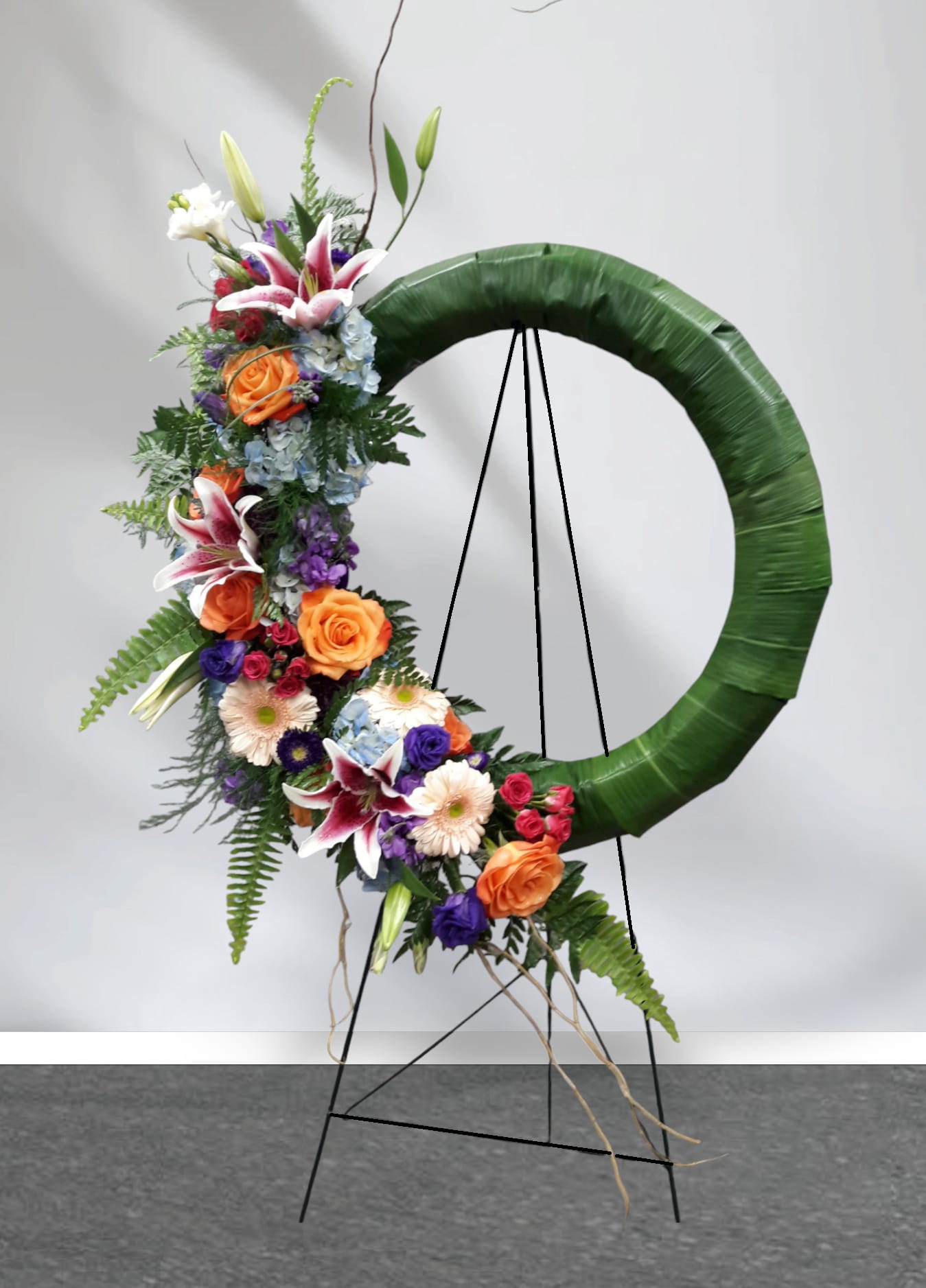 Floral standing wreath with mixed blooms on an easel