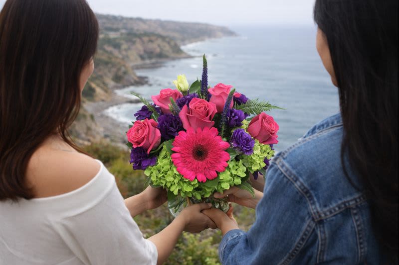 Bouquet of pink roses, purple blooms, and a pink gerbera daisy