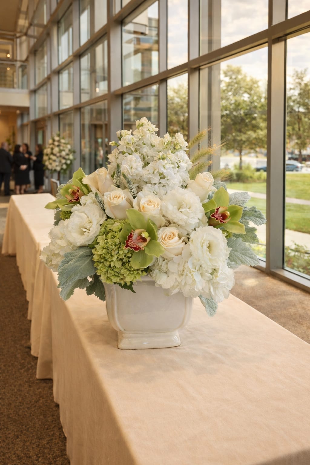 White floral centerpiece in a ceramic vase on a table